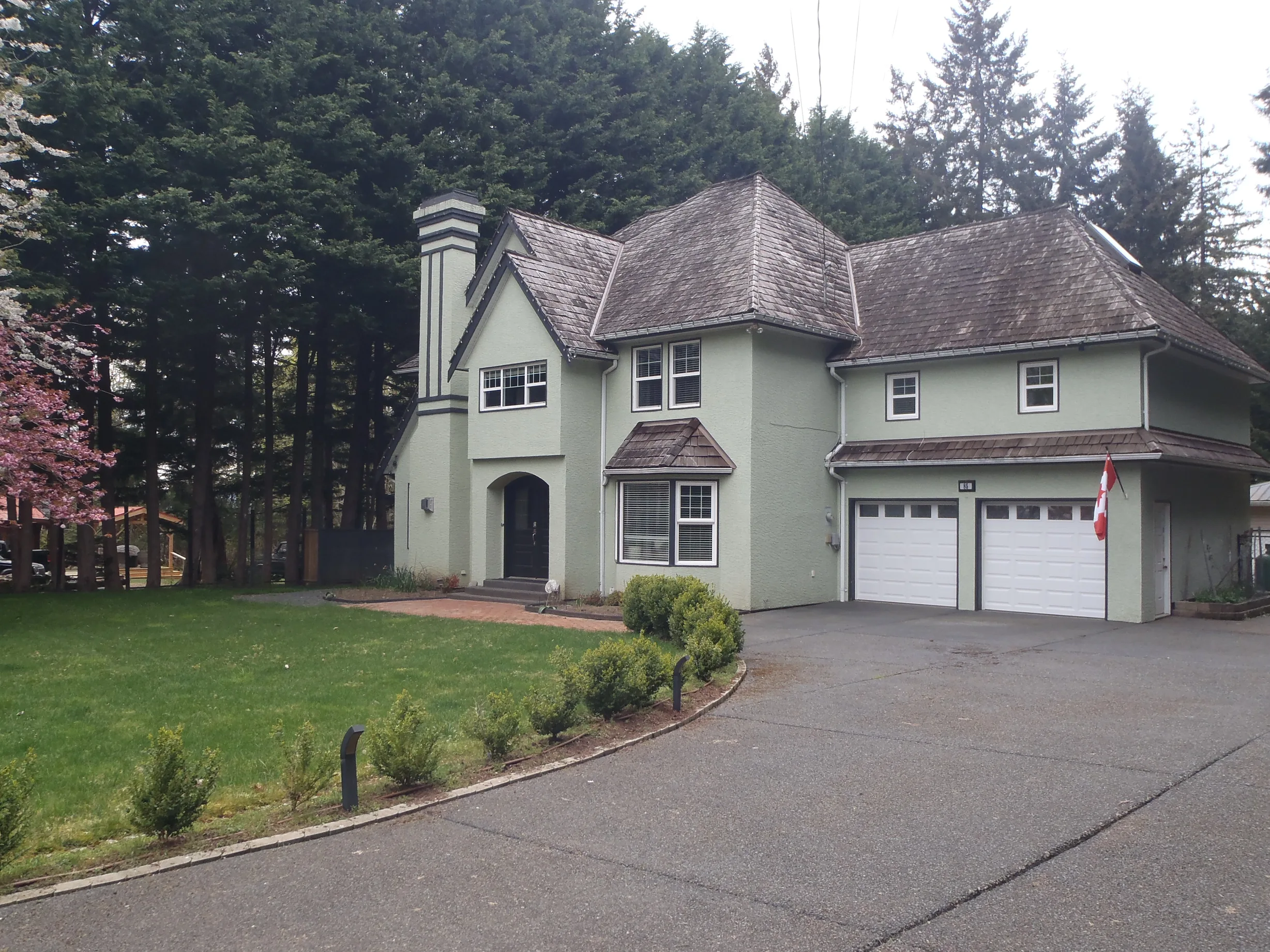 Before: a worn out wood shake roof on the home, Bowser, British Columbia, ahead of a Deep Charcoal Interlock Slate aluminum roof
