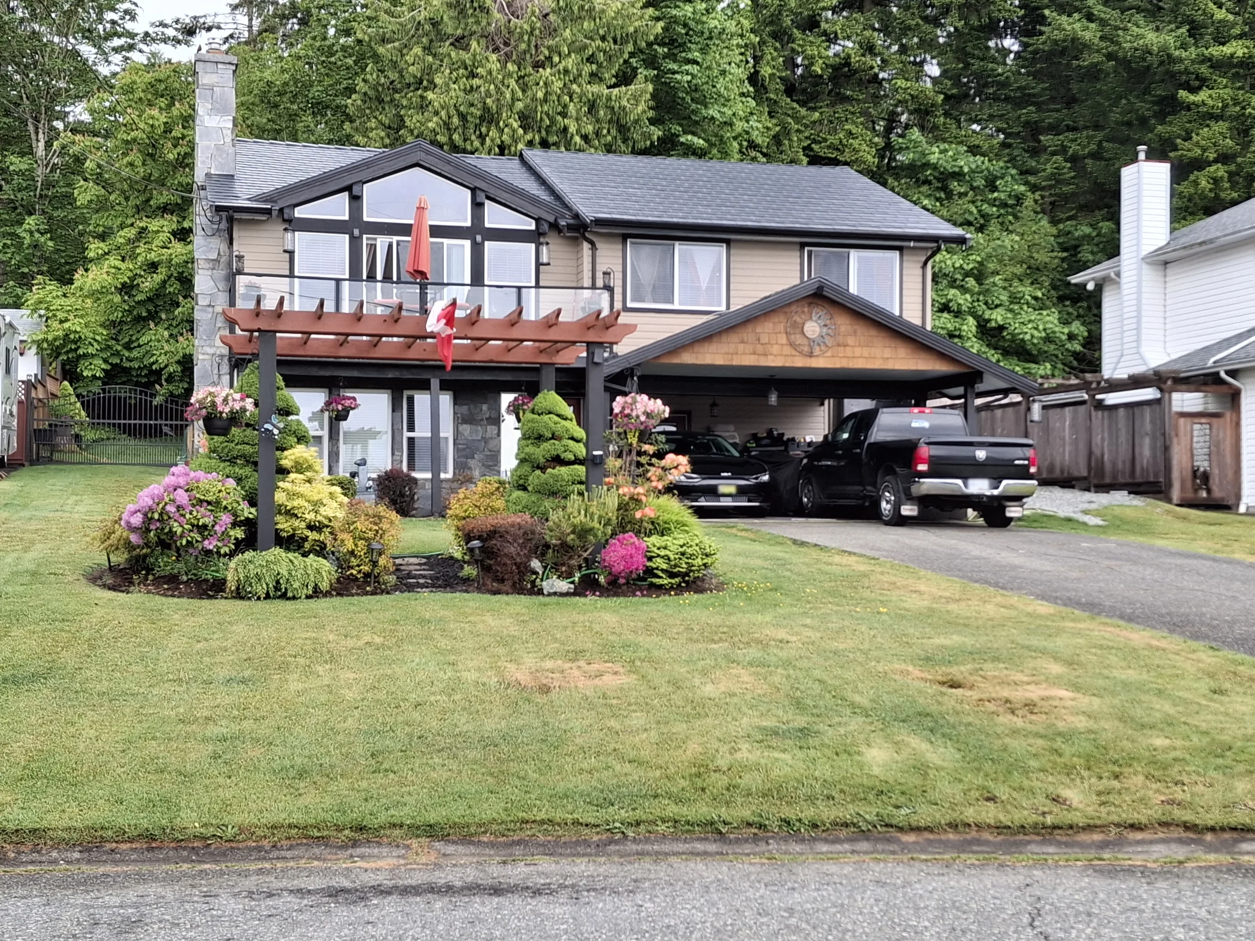 Black Interlock Slate aluminum roof on a two-storey home with a brown metal roof and brown trim, Chemainus, British Columbia