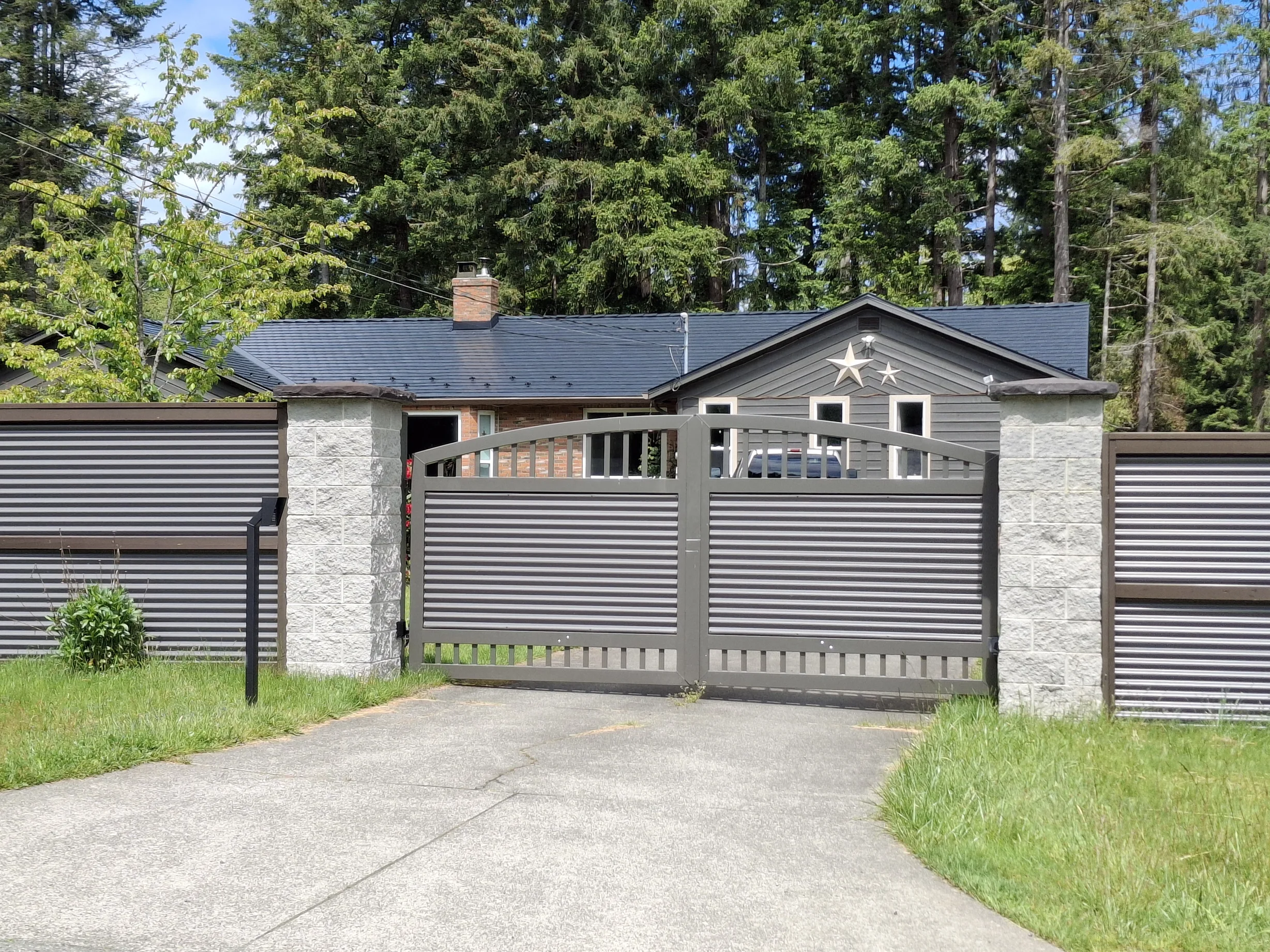 Black Interlock Slate aluminum roof on a grey ranch-style home with a metal roof in a coastal, Comox, British Columbia
