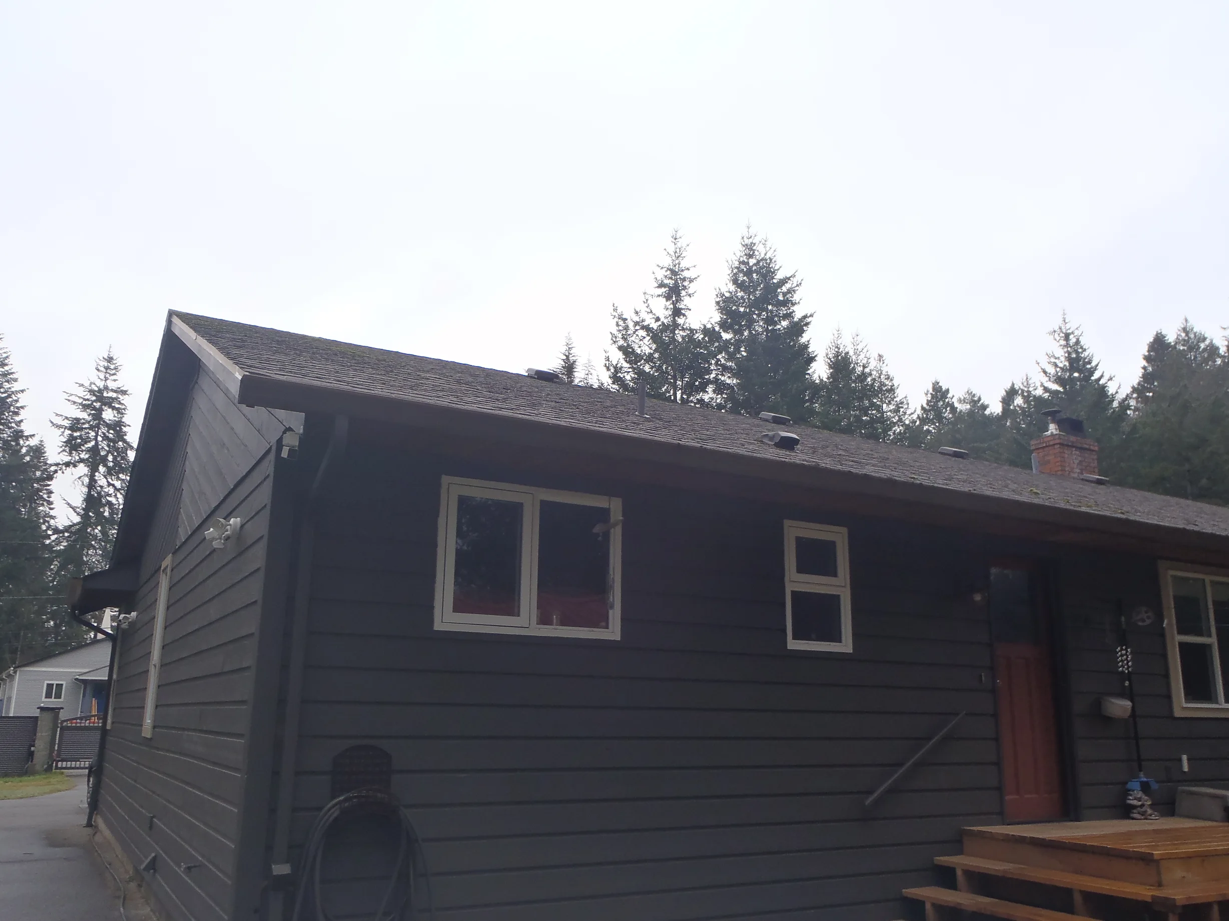 Before: a leaking asphalt shingle roof on the home, Comox, British Columbia, ahead of a Black Interlock Slate aluminum roof