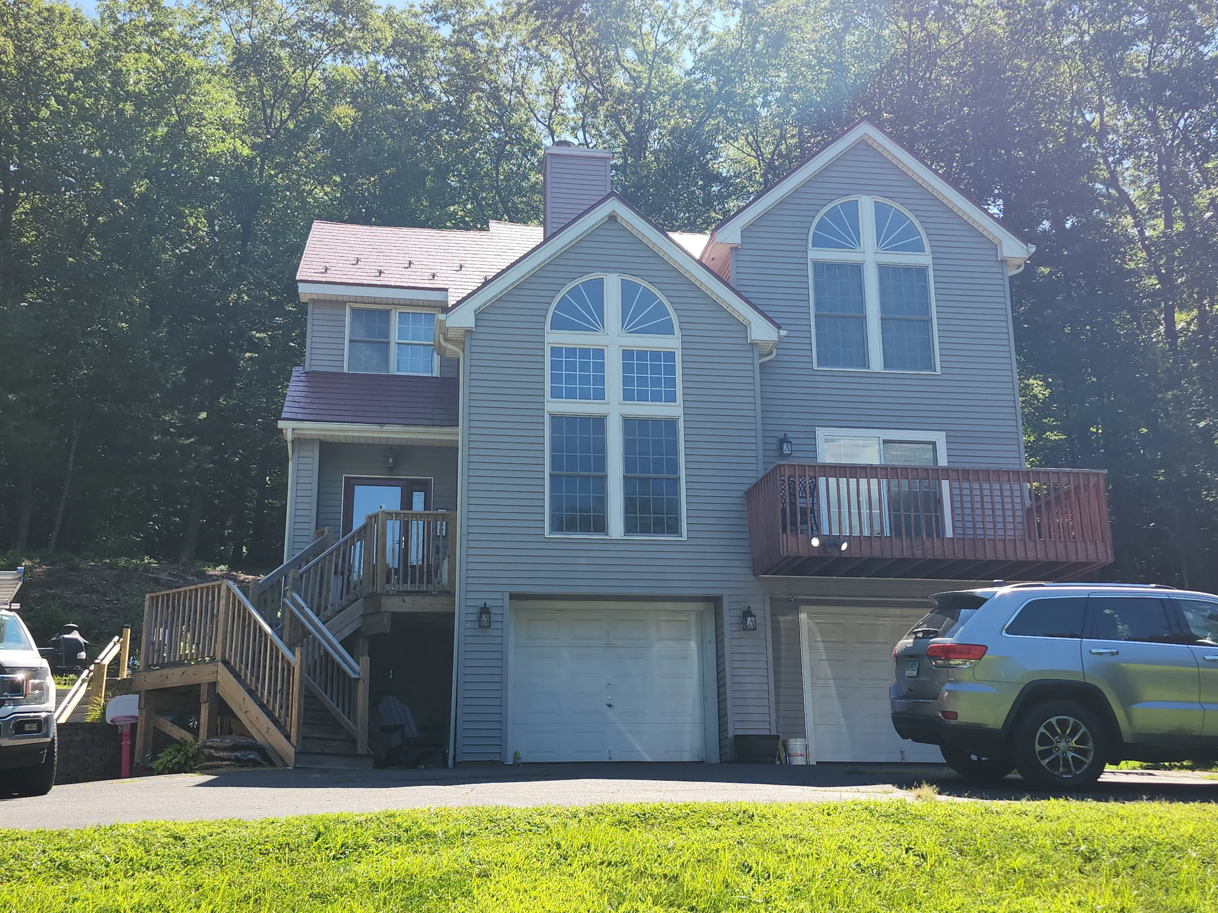 Tile Red Interlock Slate aluminum roof on a two-storey home with a grey metal roof and dormers among, Granby, Connecticut