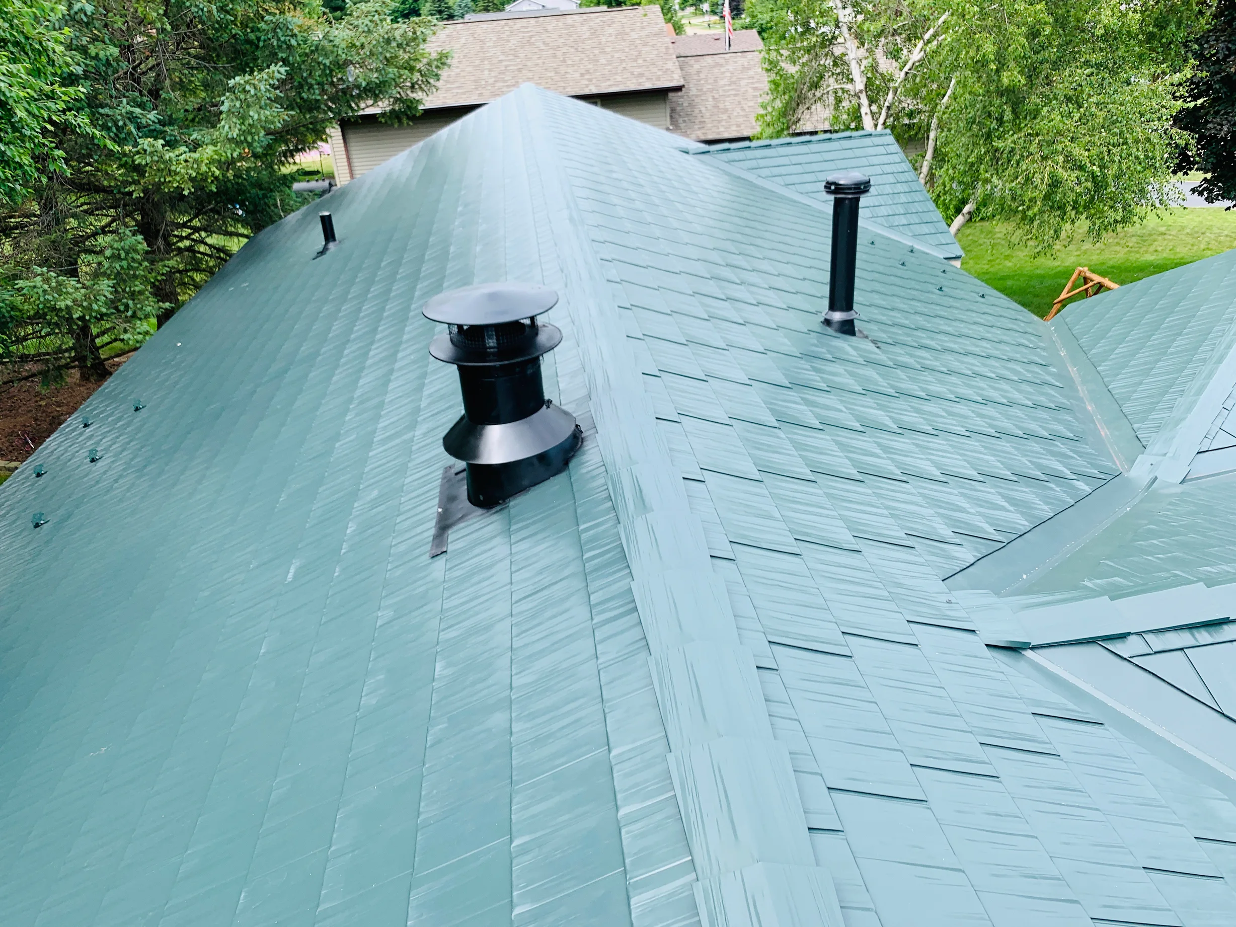 Hunter Green Interlock Shingle aluminum roof on a single-family home with hunter green roof in a forested, Winnebago, Illinois