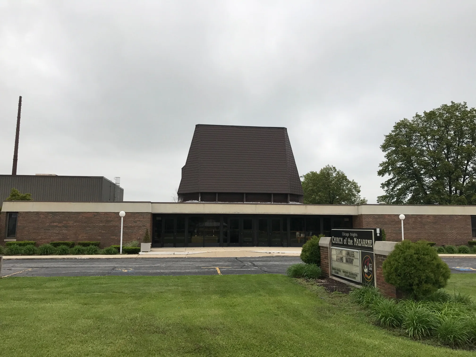 White Interlock IB Membrane aluminum roof on a red brick church with a brown roof in a suburban setting, Chicago Heights, Illinois