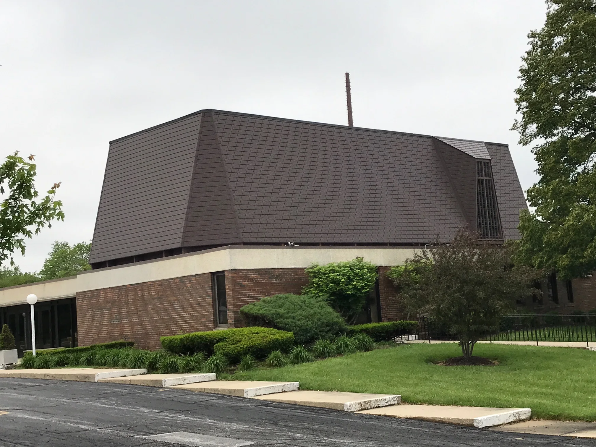 White Interlock IB Membrane aluminum roof on a brown single-family home with a chimney among tall trees, Chicago Heights, Illinois