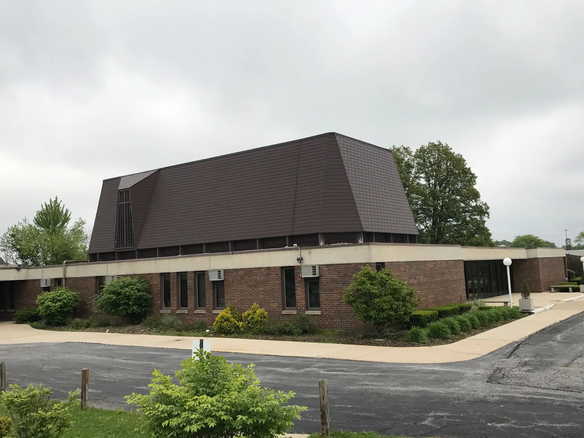 White Interlock IB Membrane aluminum roof on a brown brick home with a metal roof among trees and houses, Chicago Heights, Illinois