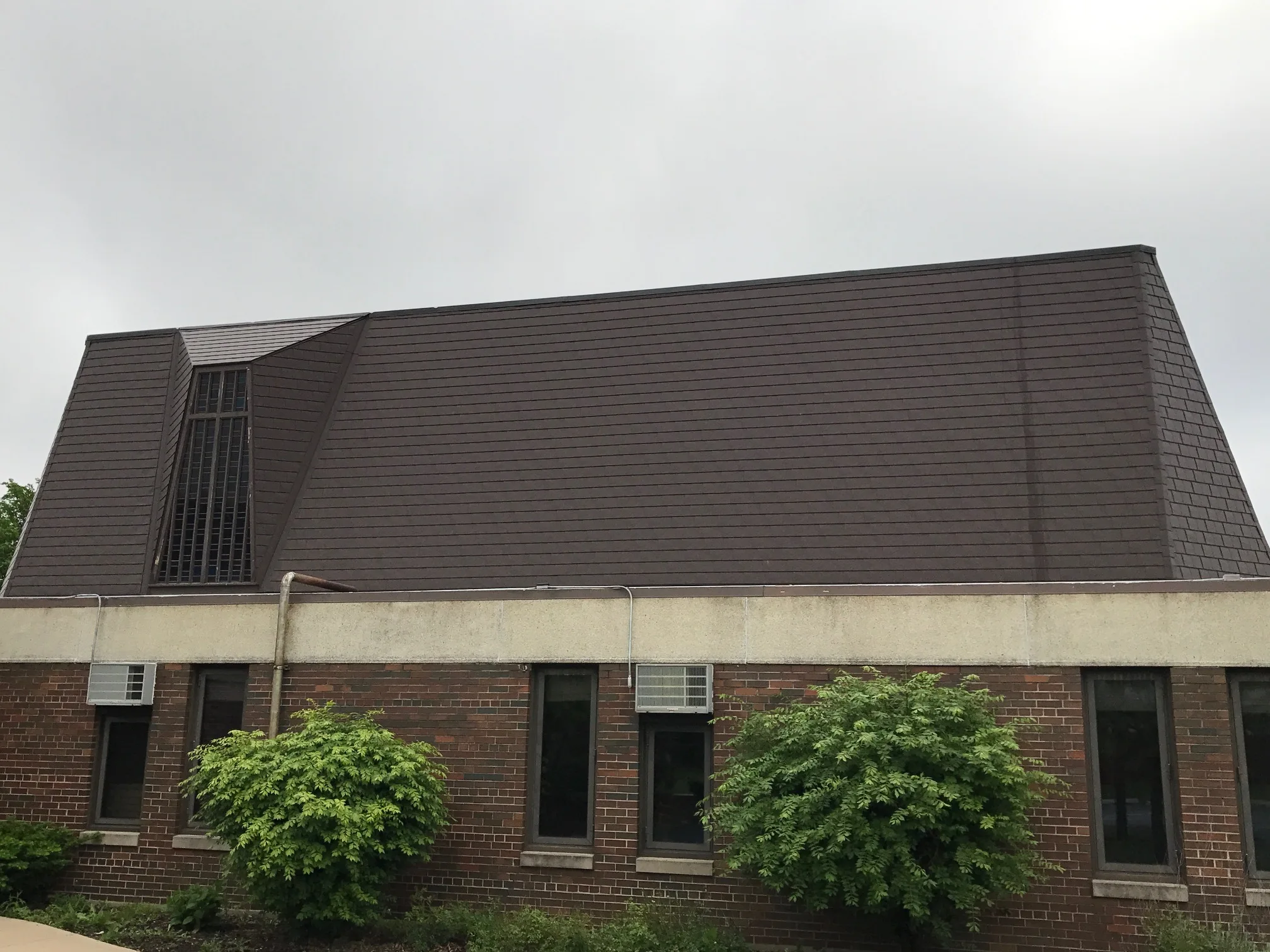 White Interlock IB Membrane aluminum roof on a red brick home with dormers in an urban area, Chicago Heights, Illinois