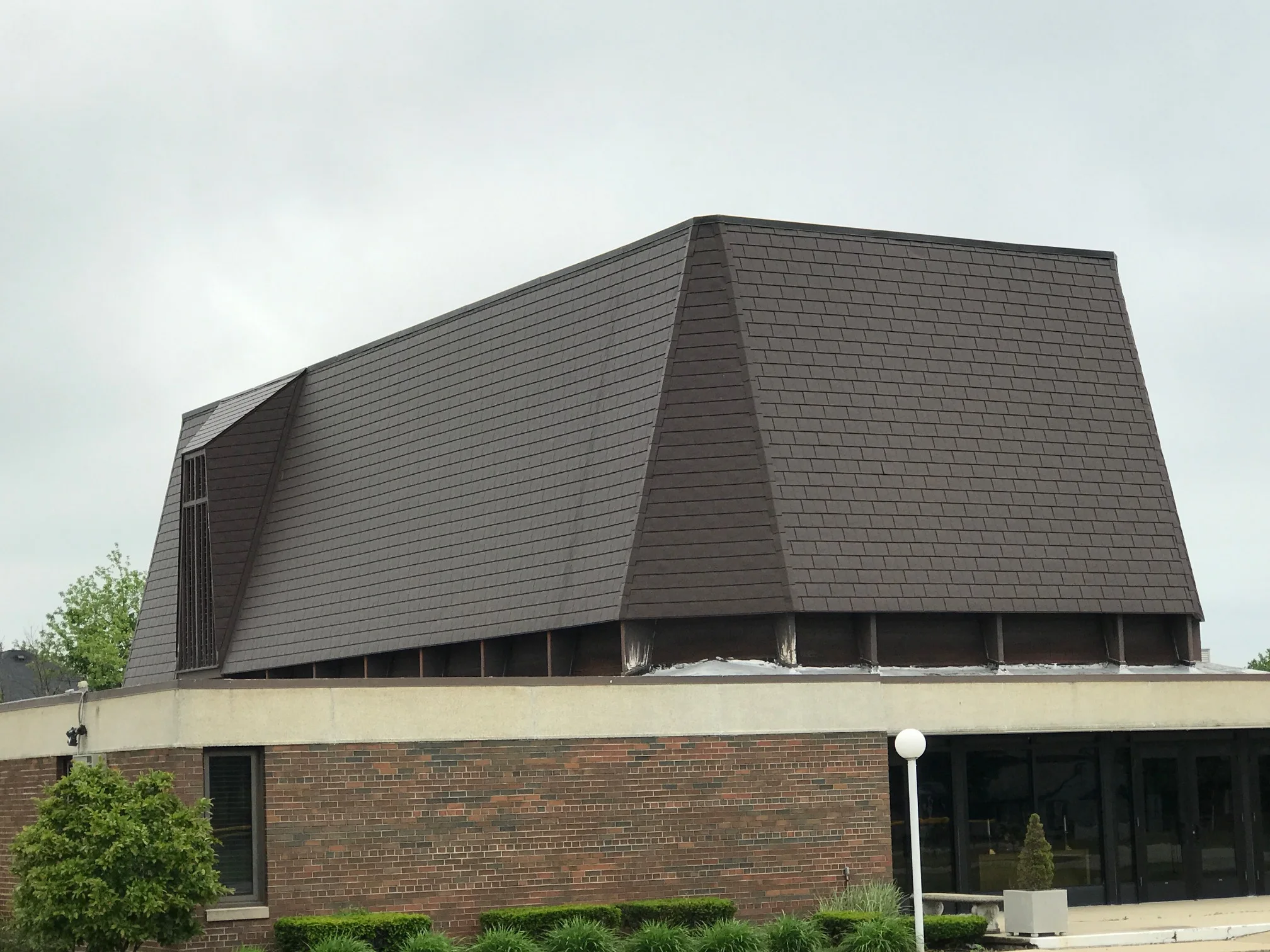 White Interlock IB Membrane aluminum roof on a white two-storey home with a metal roof and a grey sky, Chicago Heights, Illinois