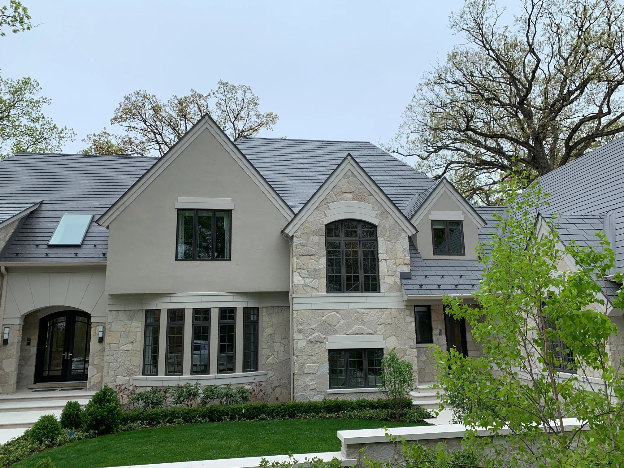 Musket Grey Interlock Slate aluminum roof on a cream-coloured two-storey home with stone accents among, Long Grove, Illinois