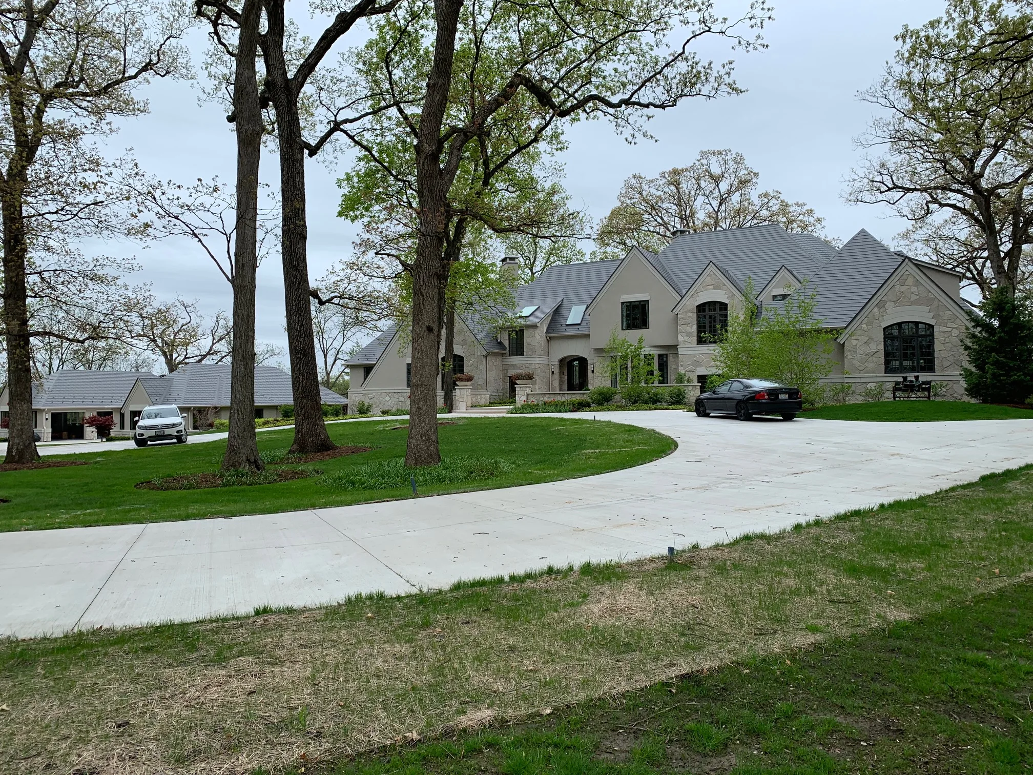 Musket Grey Interlock Slate aluminum roof on a two-storey Colonial home with dormers among tall trees, Long Grove, Illinois