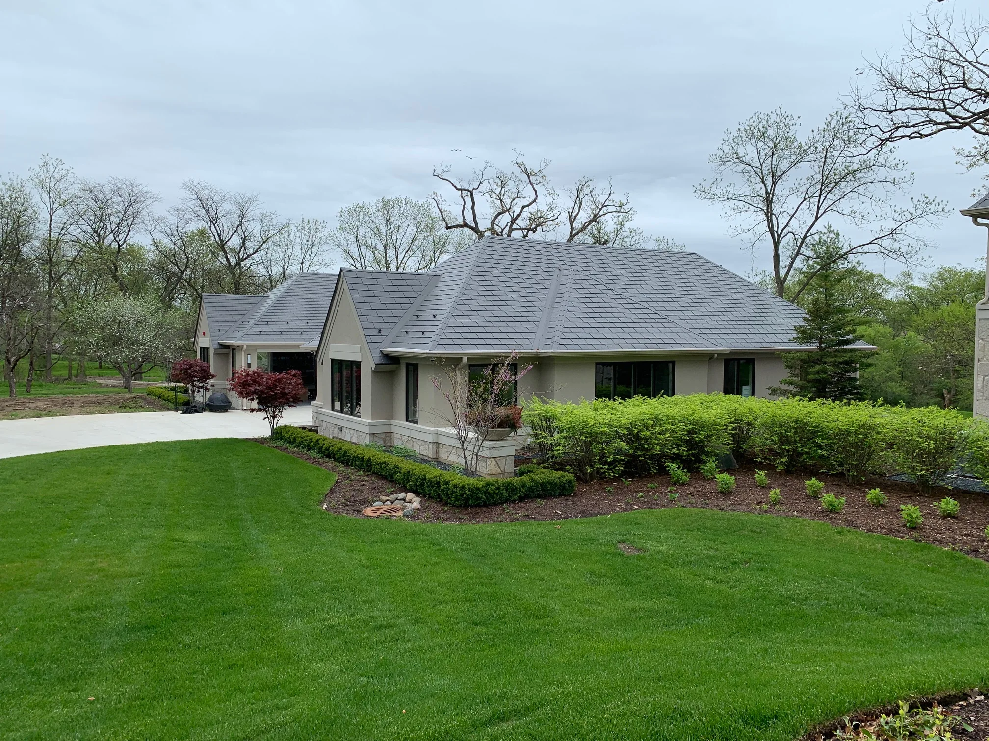 Musket Grey Interlock Slate aluminum roof on a beige ranch home with a grey metal roof in a forested, Long Grove, Illinois