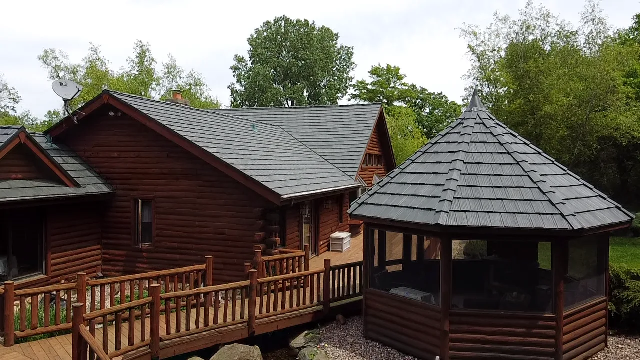 Hunter Green Interlock Shake aluminum roof on a brown chalet-style home with a hunter green metal roof in, Harvard, Illinois