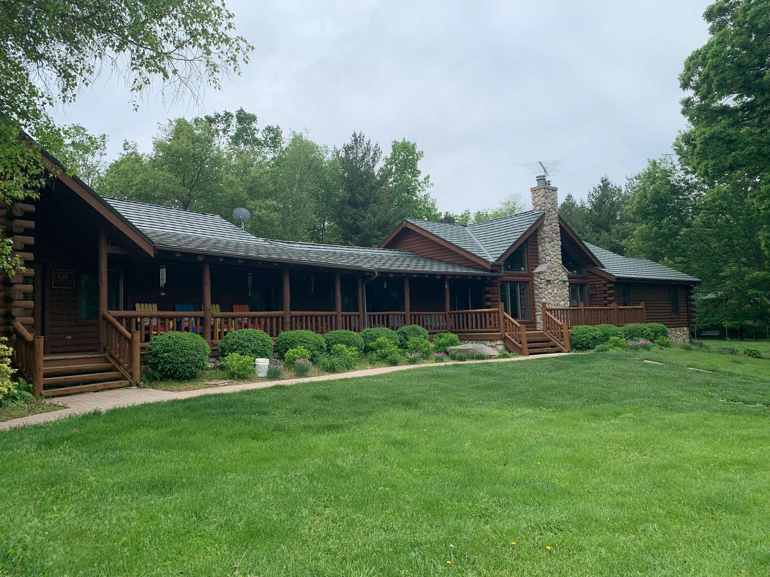 Hunter Green Interlock Shake aluminum roof on a brown ranch home with a green metal roof in a wooded area, Harvard, Illinois