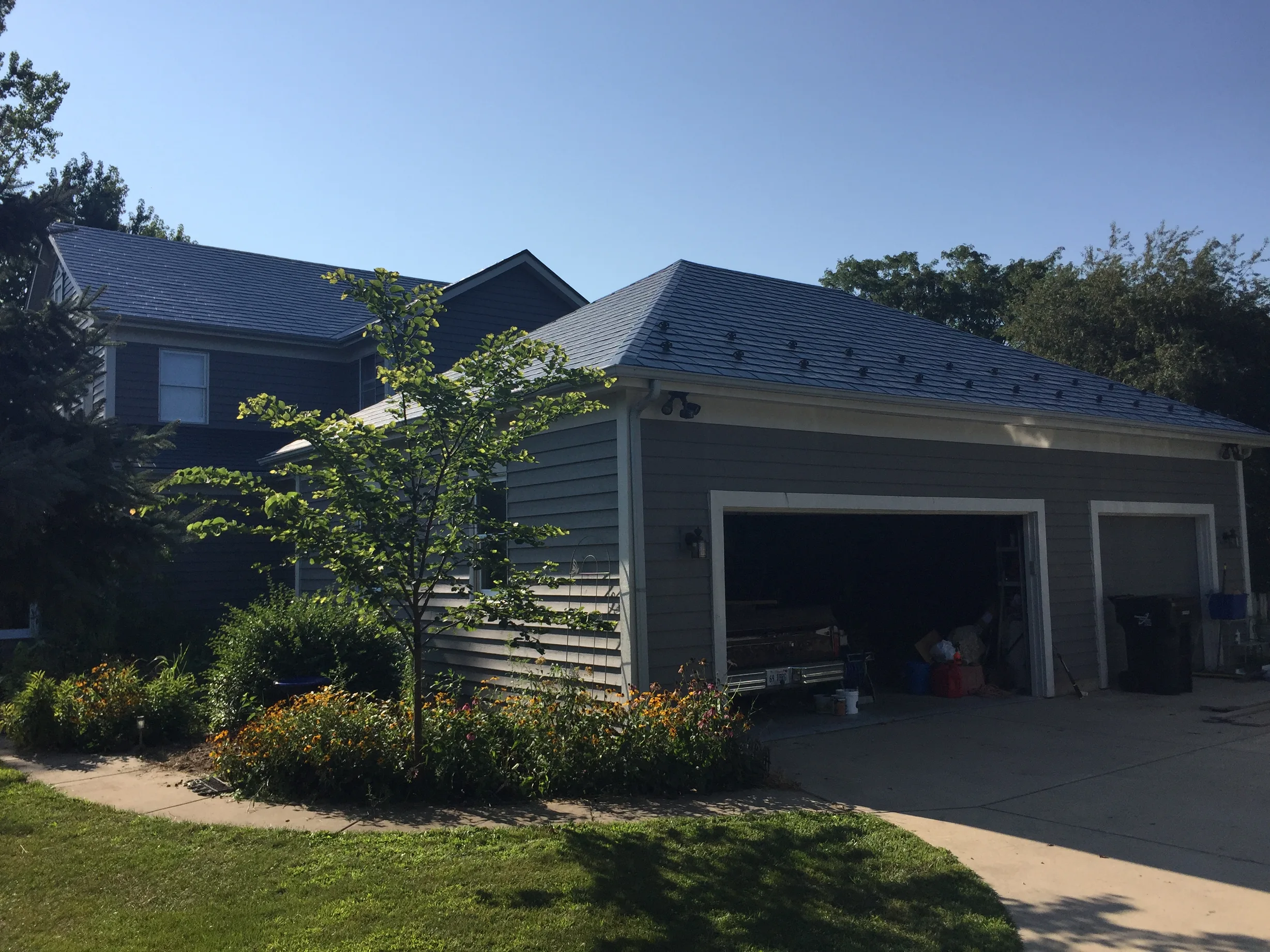 Deep Charcoal Interlock Slate aluminum roof being installed on a grey modern home with a metal roof under construction, Plano, Illinois