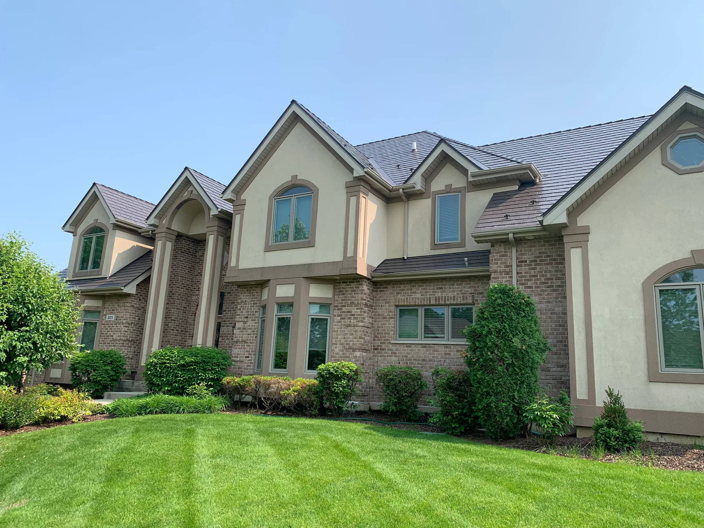 Tudor Brown Interlock Slate aluminum roof on a Tudor brown home with a slate roof in a lush green, Roselle, Illinois