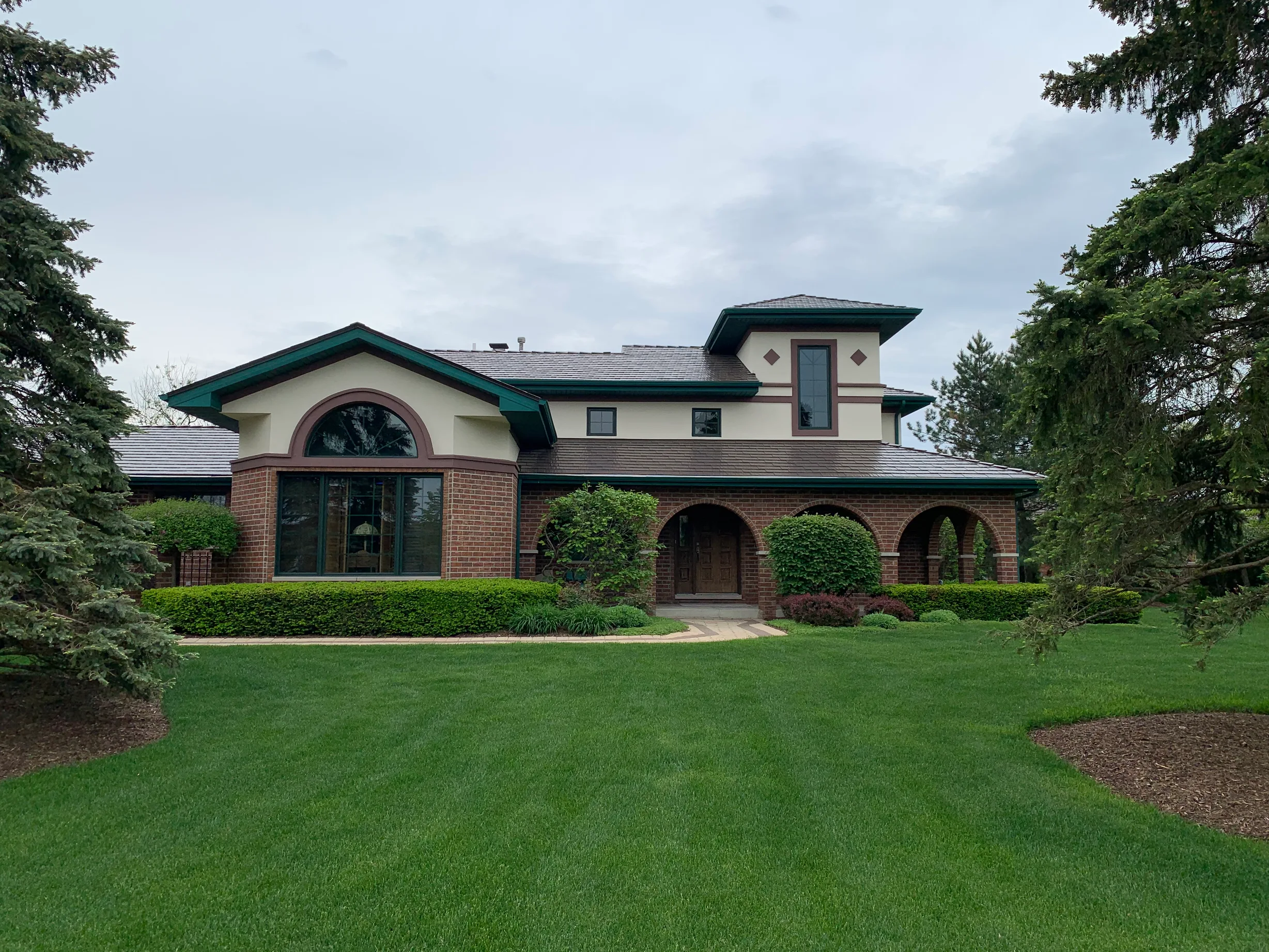 Colonial Brown Interlock Cedar Shingle aluminum roof on a Colonial brown roof on a two-storey home among tall pines, Orland Park, Illinois
