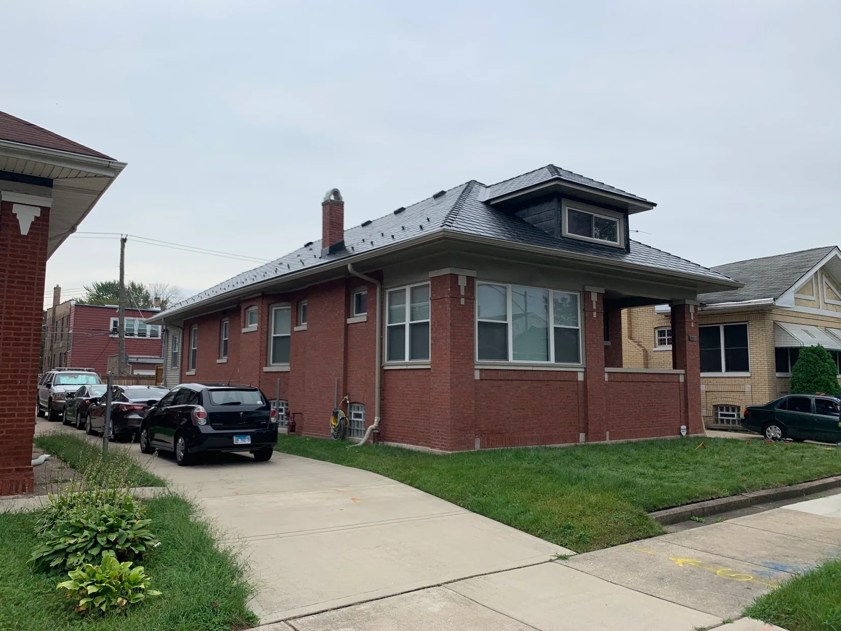 Black Interlock Slate aluminum roof on a red brick house with a black metal roof in a residential, Chicago, Illinois