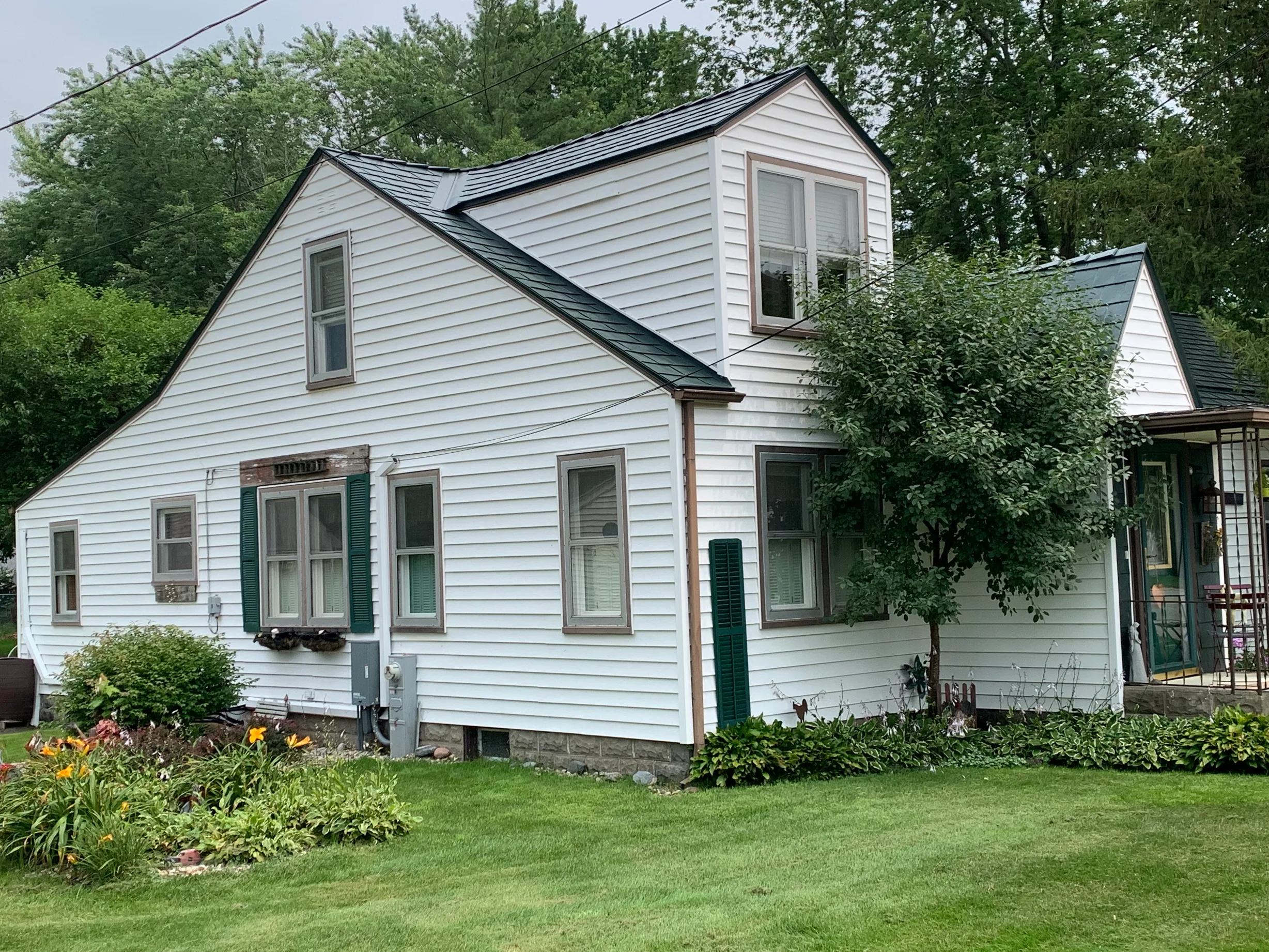 Hunter Green Interlock Slate aluminum roof on a white Cape Cod home with Hunter Green metal roof in a, Braidwood, Illinois