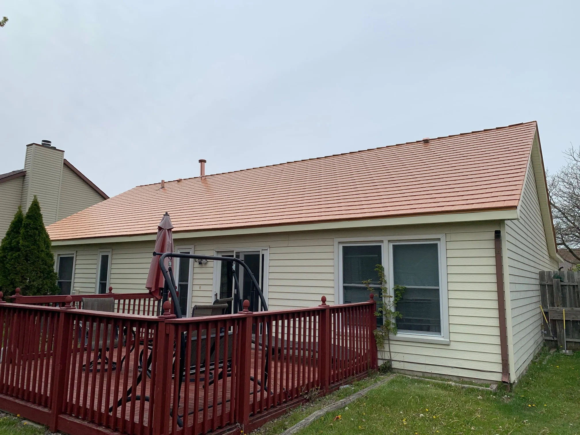 Copper Penny Interlock Cedar Shingle aluminum roof on a ranch home with beige siding under a cloudy sky, Bolingbrook, Illinois