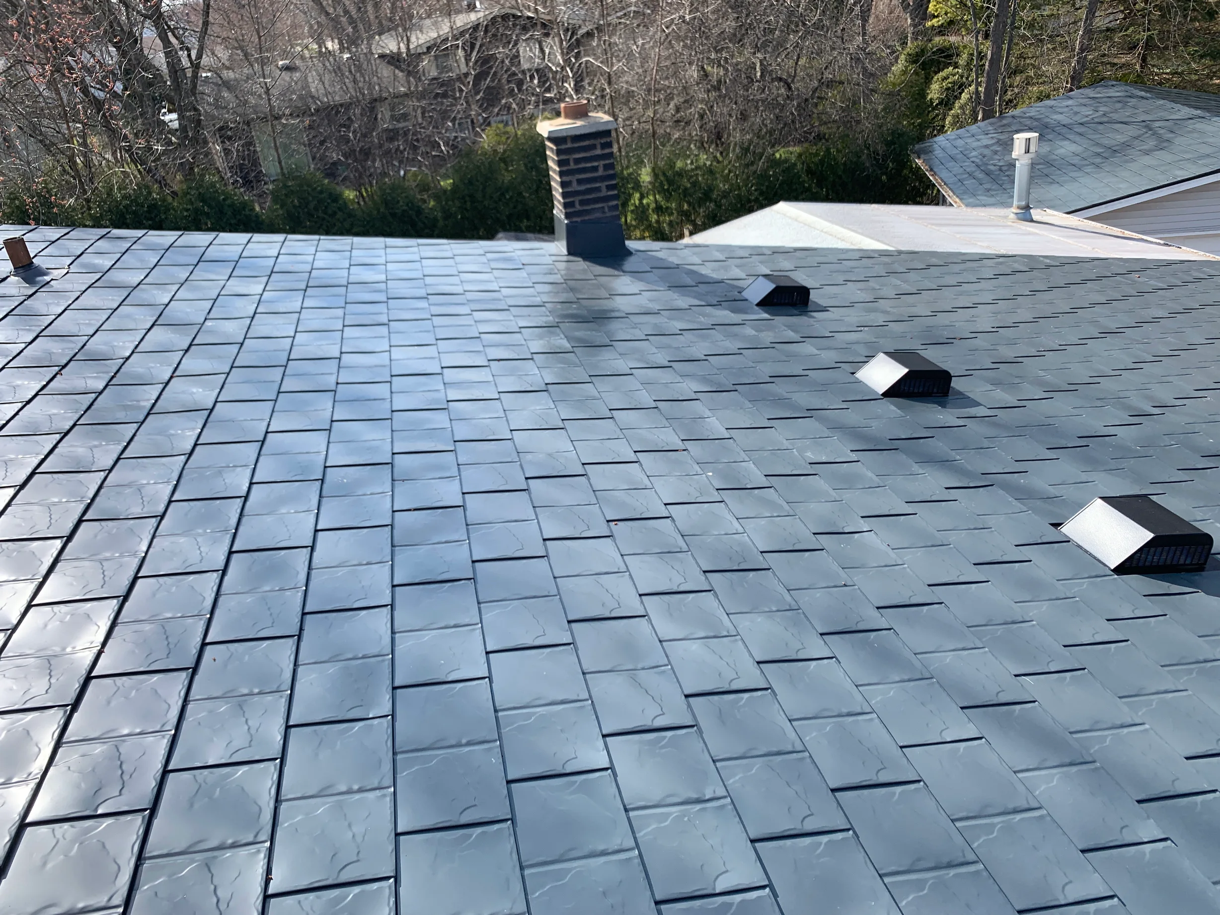Deep Charcoal Interlock Slate aluminum roof on a modern home with a metal roof in a forested urban area, Waukegan, Illinois
