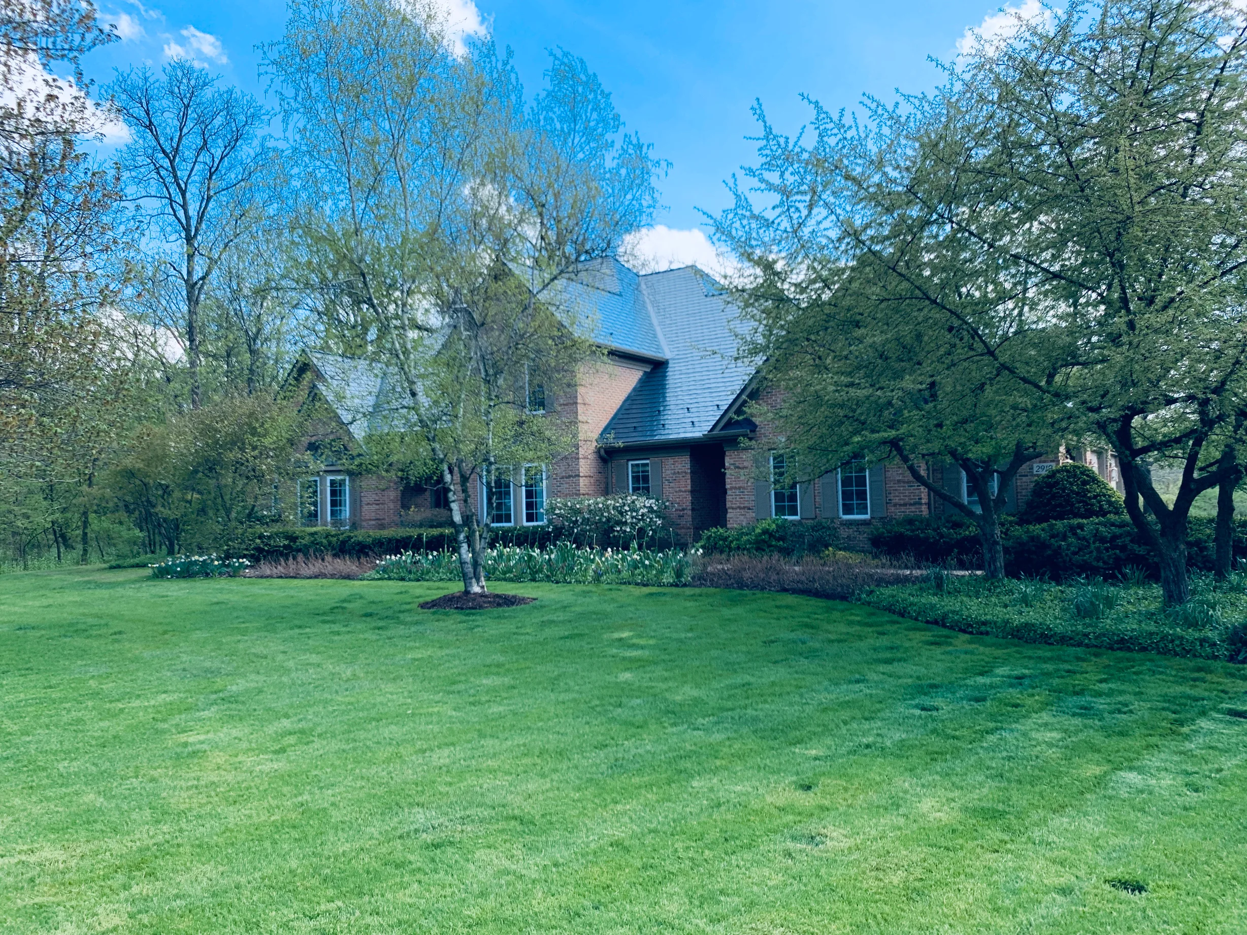 Deep Charcoal Interlock Slate aluminum roof on a brick two-storey colonial home among trees in Crystal Lake, Crystal Lake, Illinois