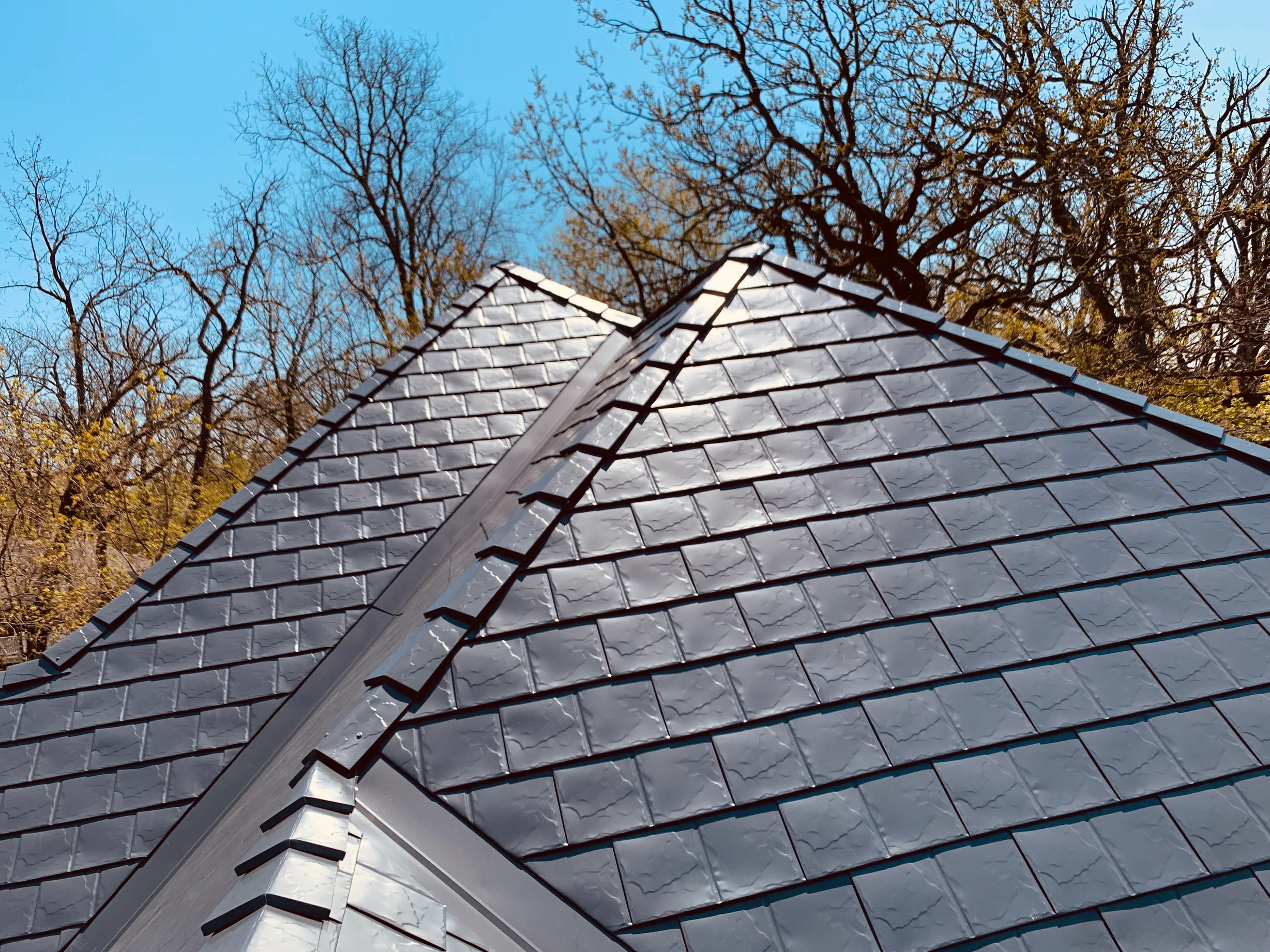 Deep Charcoal Interlock Slate aluminum roof on a gray house with a metal roof in a forest near a lake, Crystal Lake, Illinois