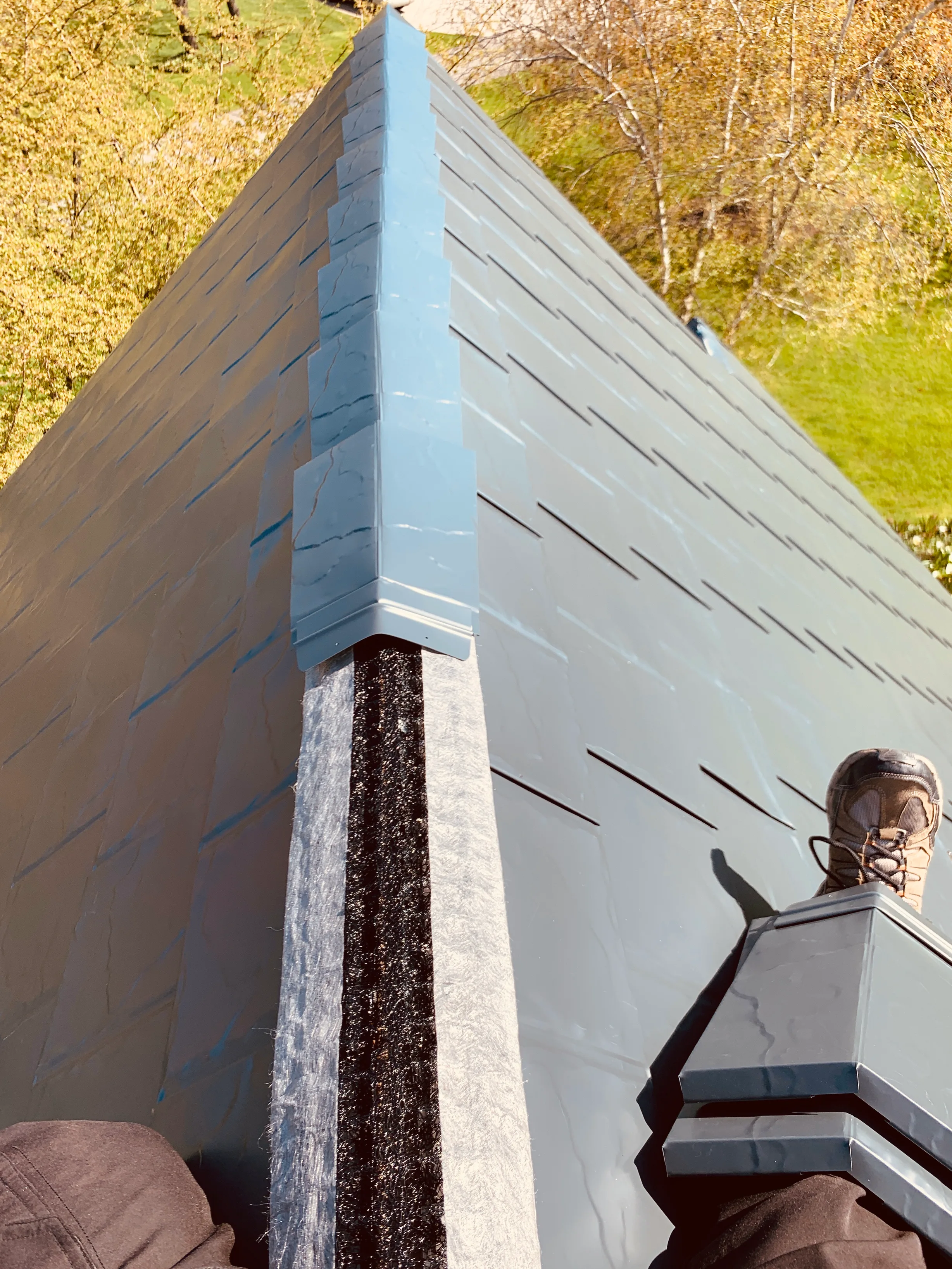 Deep Charcoal Interlock Slate aluminum roof being installed on a single-family home with a metal roof and a green lawn, Crystal Lake, Illinois