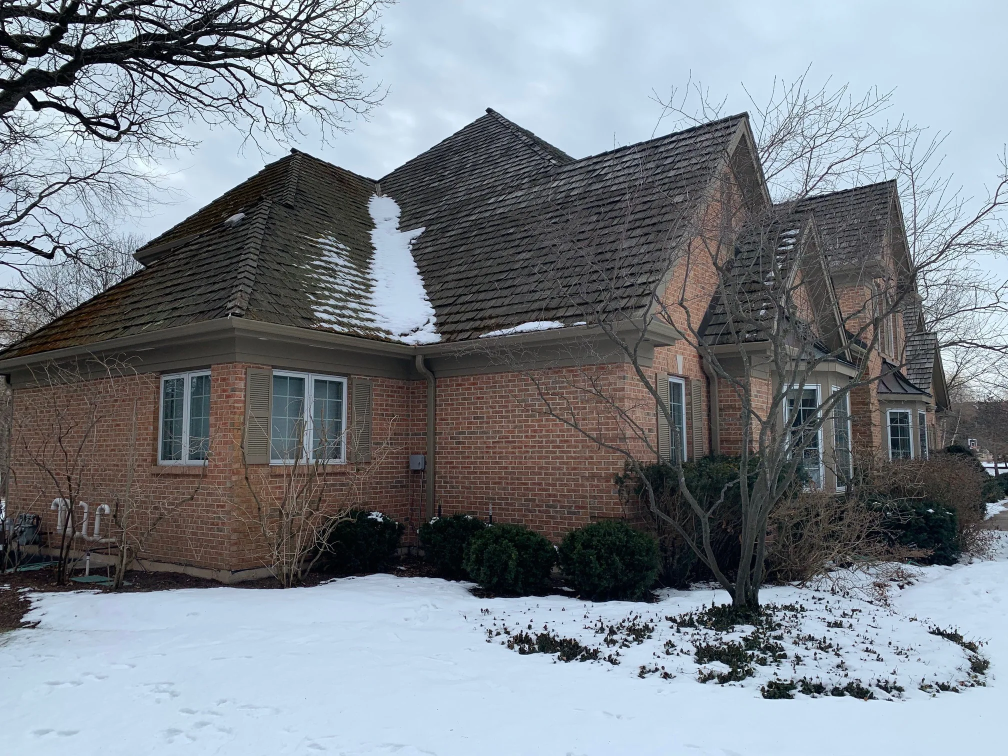 Before: a worn out wood shake roof on the home, Crystal Lake, Illinois, ahead of a Deep Charcoal Interlock Slate aluminum roof