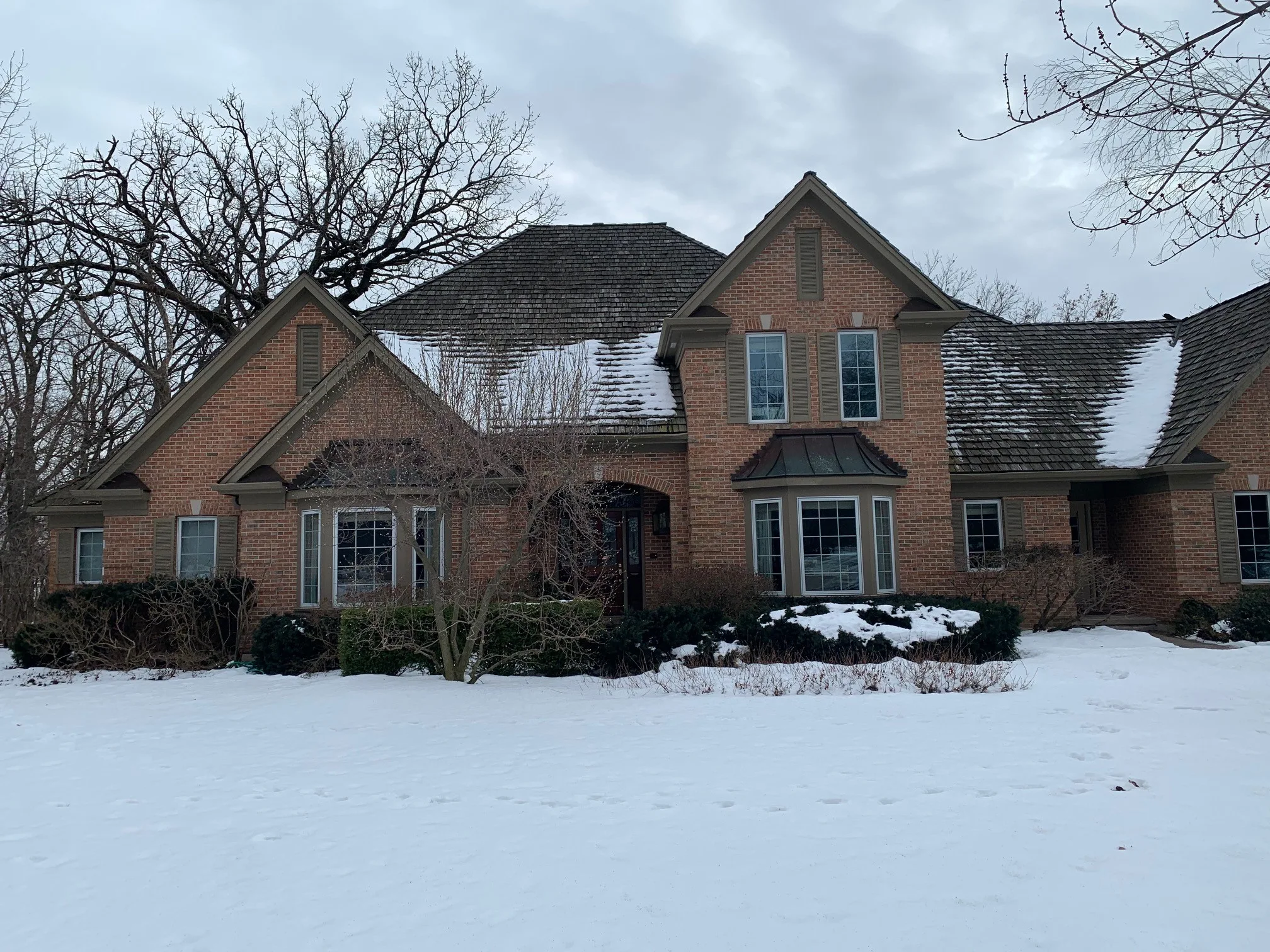 Before: a worn out wood shake roof on the home, Crystal Lake, Illinois, ahead of a Deep Charcoal Interlock Slate aluminum roof