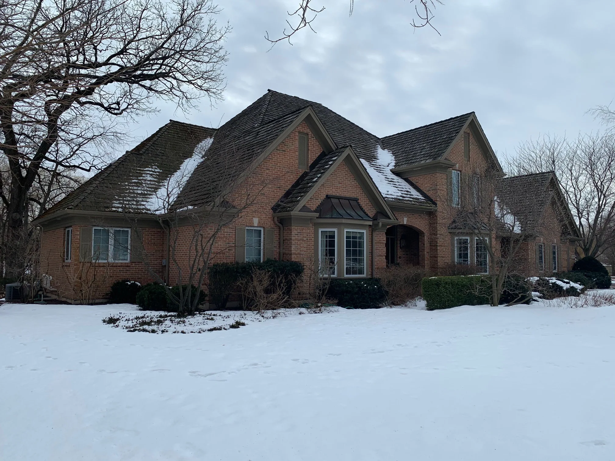 Before: a worn out wood shake roof on the home, Crystal Lake, Illinois, ahead of a Deep Charcoal Interlock Slate aluminum roof