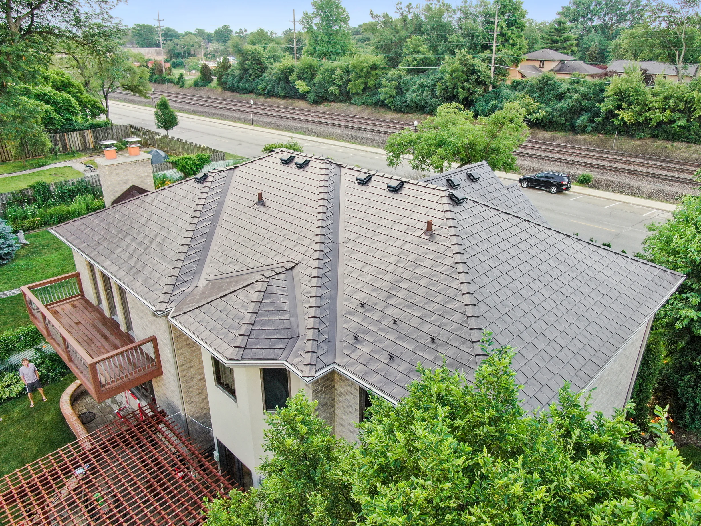 Colonial Brown Interlock Slate aluminum roof on a colonial home with a grey metal roof in a wooded suburban, Calredon Hills, Illinois