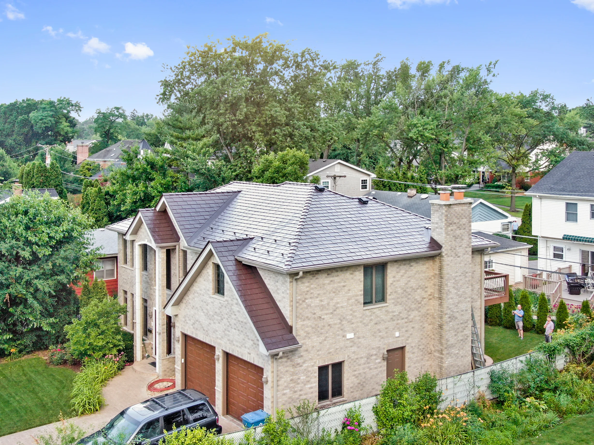 Colonial Brown Interlock Slate aluminum roof on a colonial home with a metal roof in a forested area, Calredon Hills, Illinois