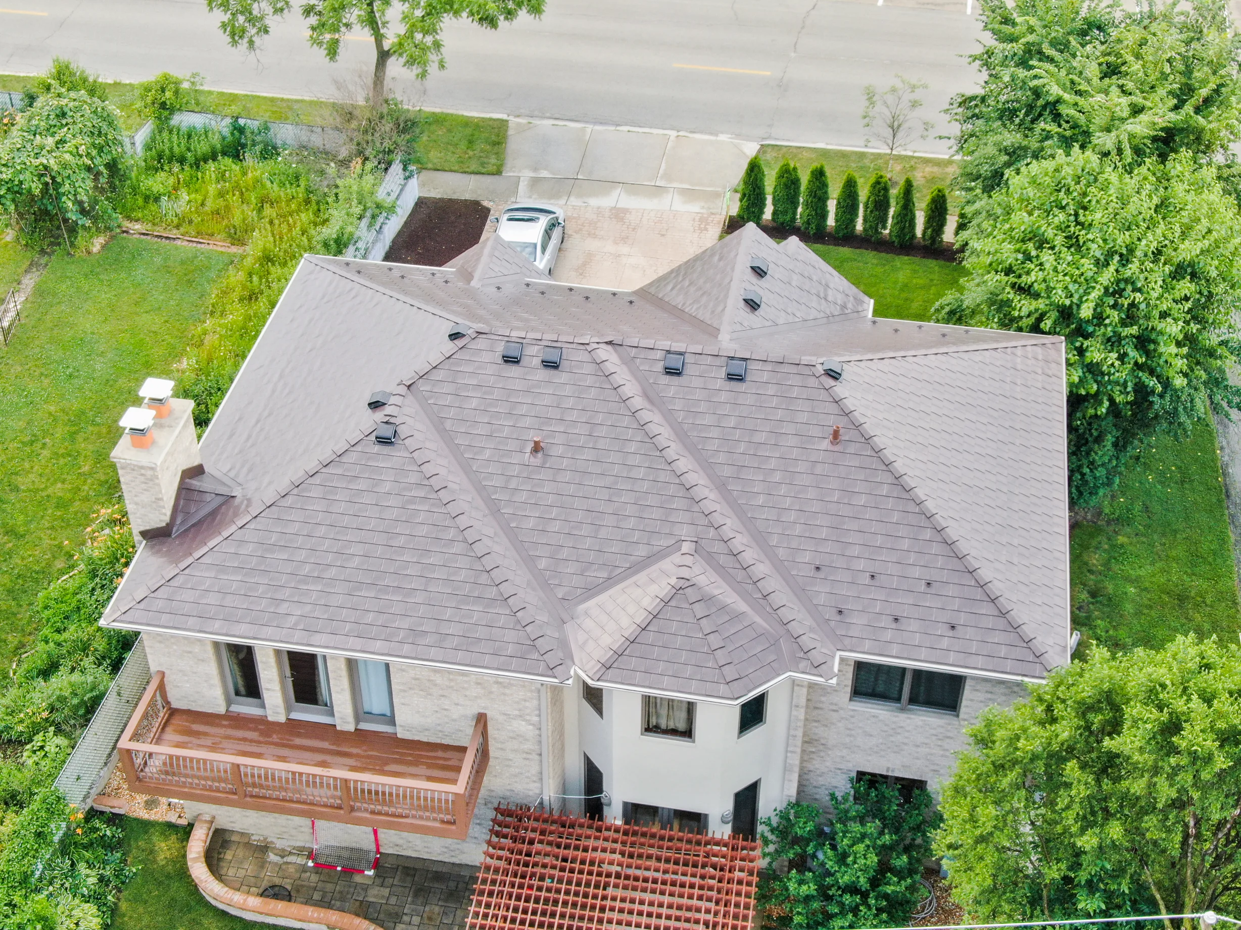 Colonial Brown Interlock Slate aluminum roof on a Colonial brown metal roof on a two-storey white home, Calredon Hills, Illinois