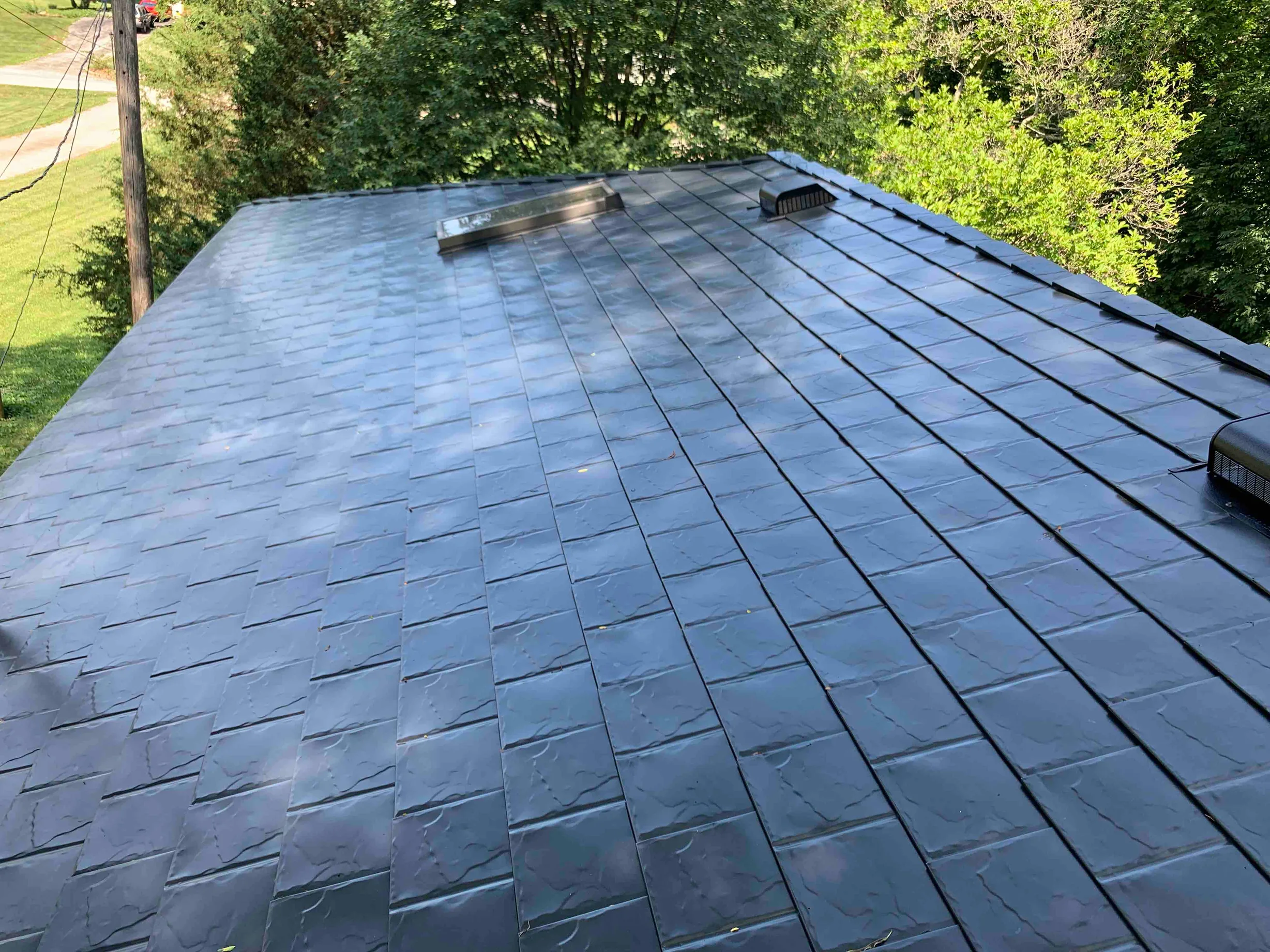 Black Interlock Slate aluminum roof on a black ranch house with a metal roof in a forested, Lombard, Illinois