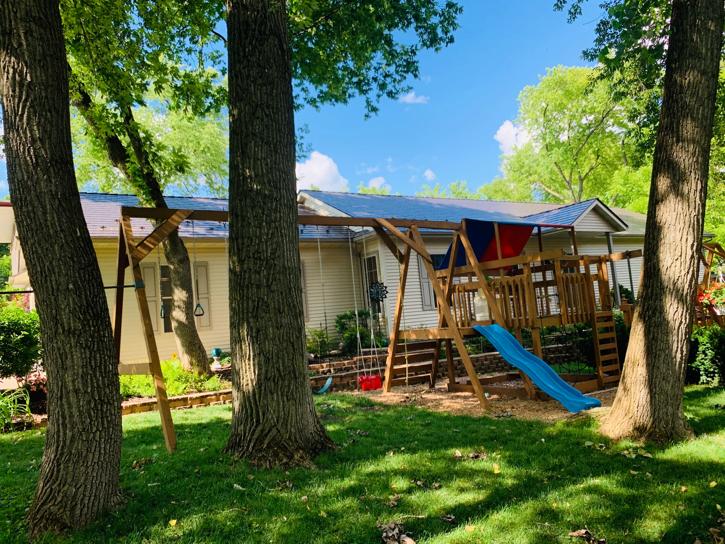 Tudor Brown Interlock Cedar Shingle aluminum roof on a Tudor-style home with a brown metal roof in a wooded area, Algonquin, Illinois