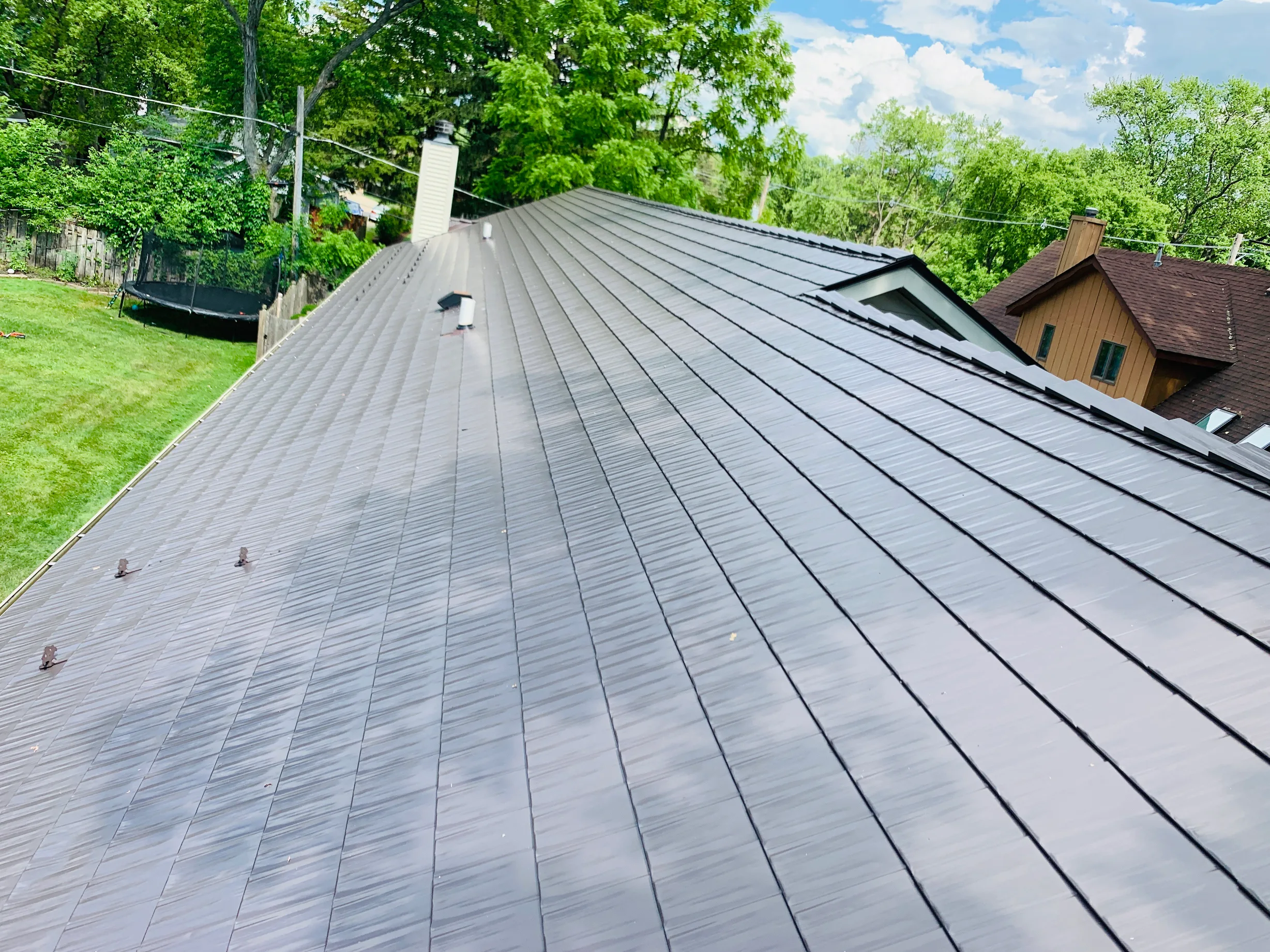 Tudor Brown Interlock Cedar Shingle aluminum roof on a Tudor home with a brown metal roof in a wooded area, Algonquin, Illinois