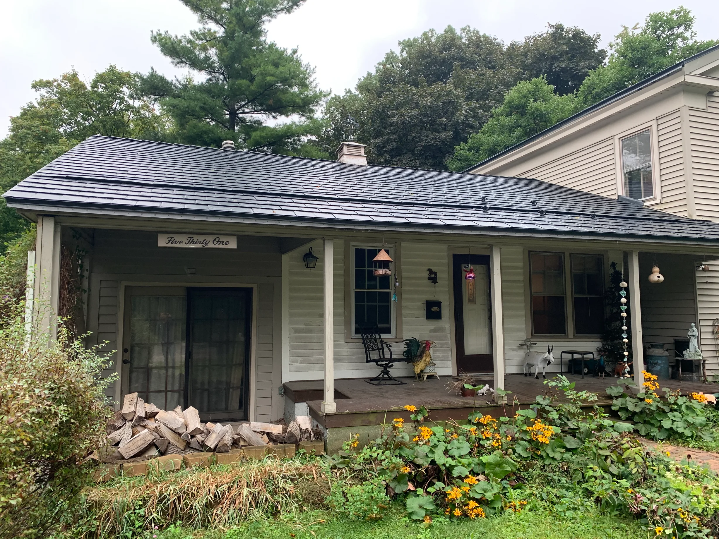 Black Interlock Slate aluminum roof on a white colonial home with dormers in a lush suburban, Woodstock, Illinois