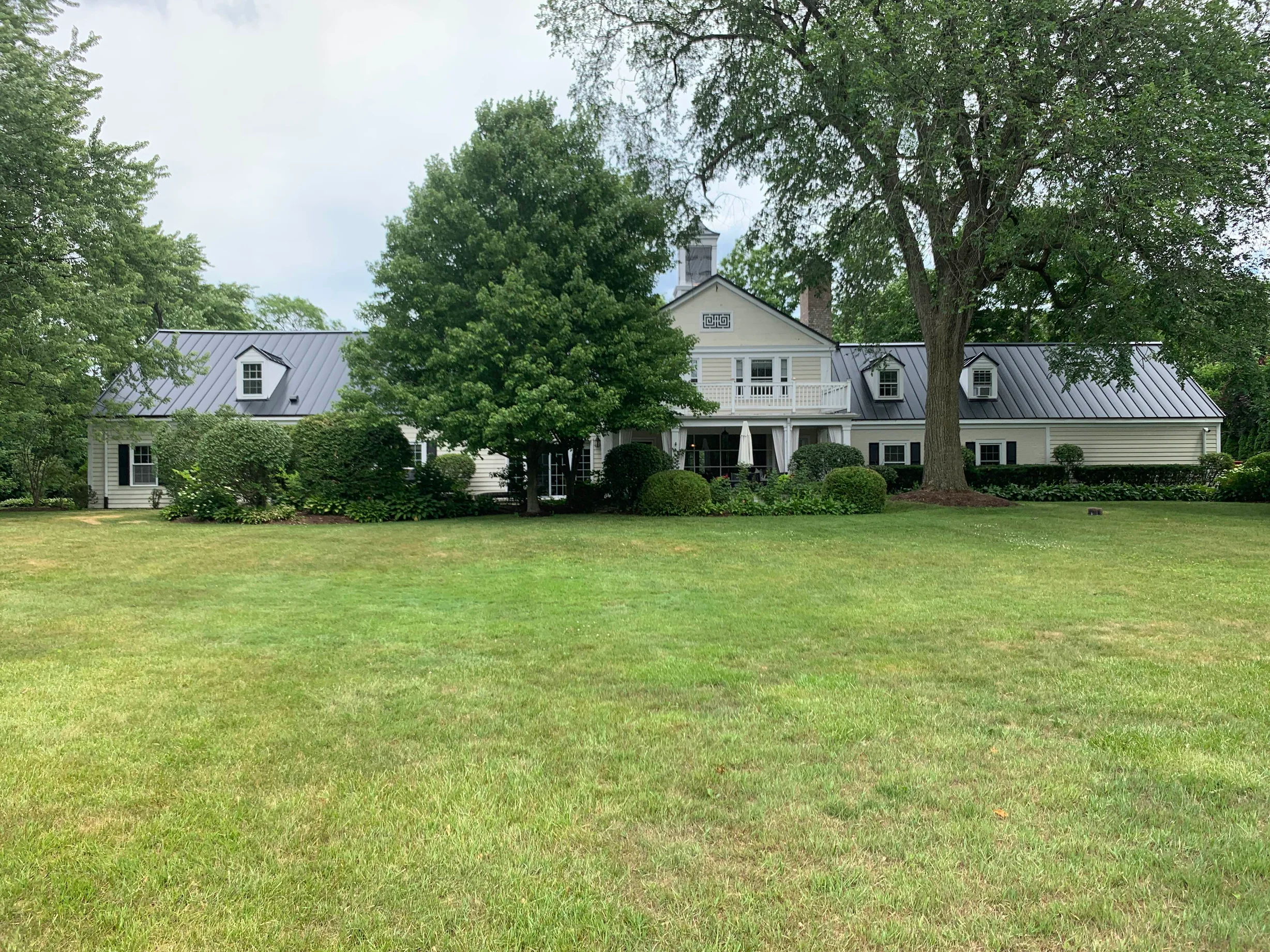 Black Interlock Standing Seam aluminum roof on a large colonial home with a grey metal roof and dormers, Lake Forest, Illinois