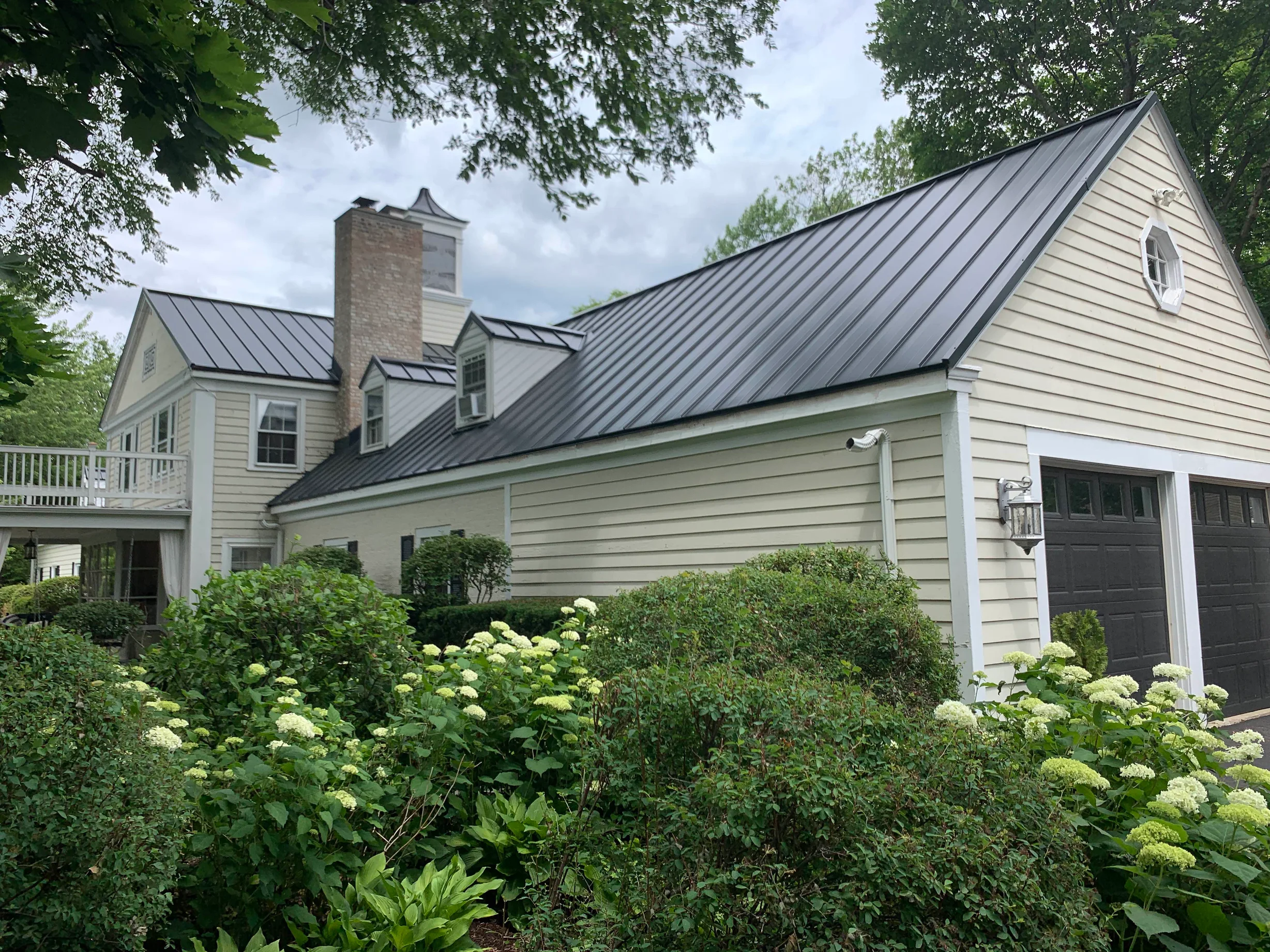 Black Interlock Standing Seam aluminum roof on a colonial home with a black metal roof, surrounded by, Lake Forest, Illinois