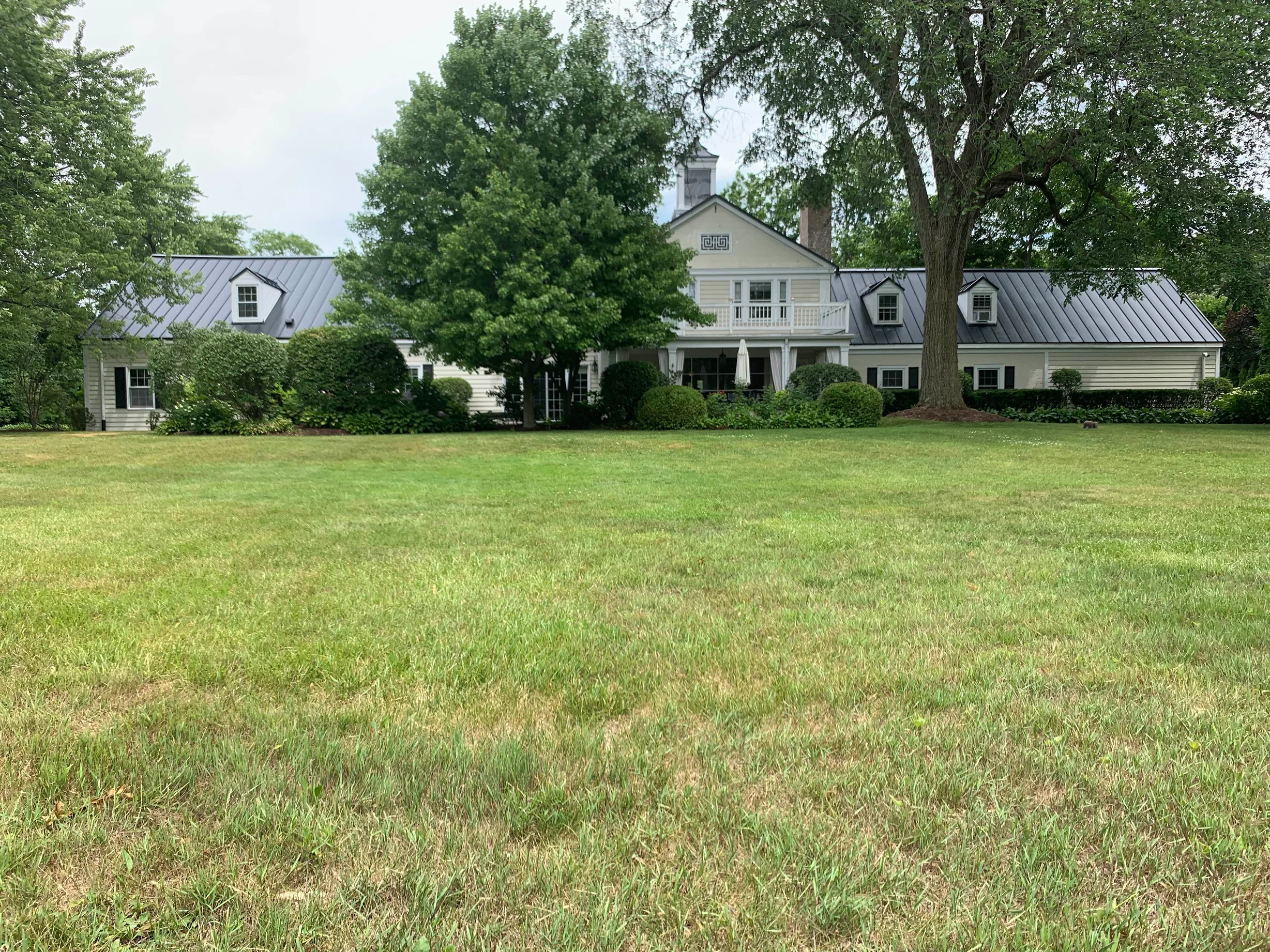 Black Interlock Standing Seam aluminum roof on a colonial home with a black metal roof in a forested, Lake Forest, Illinois