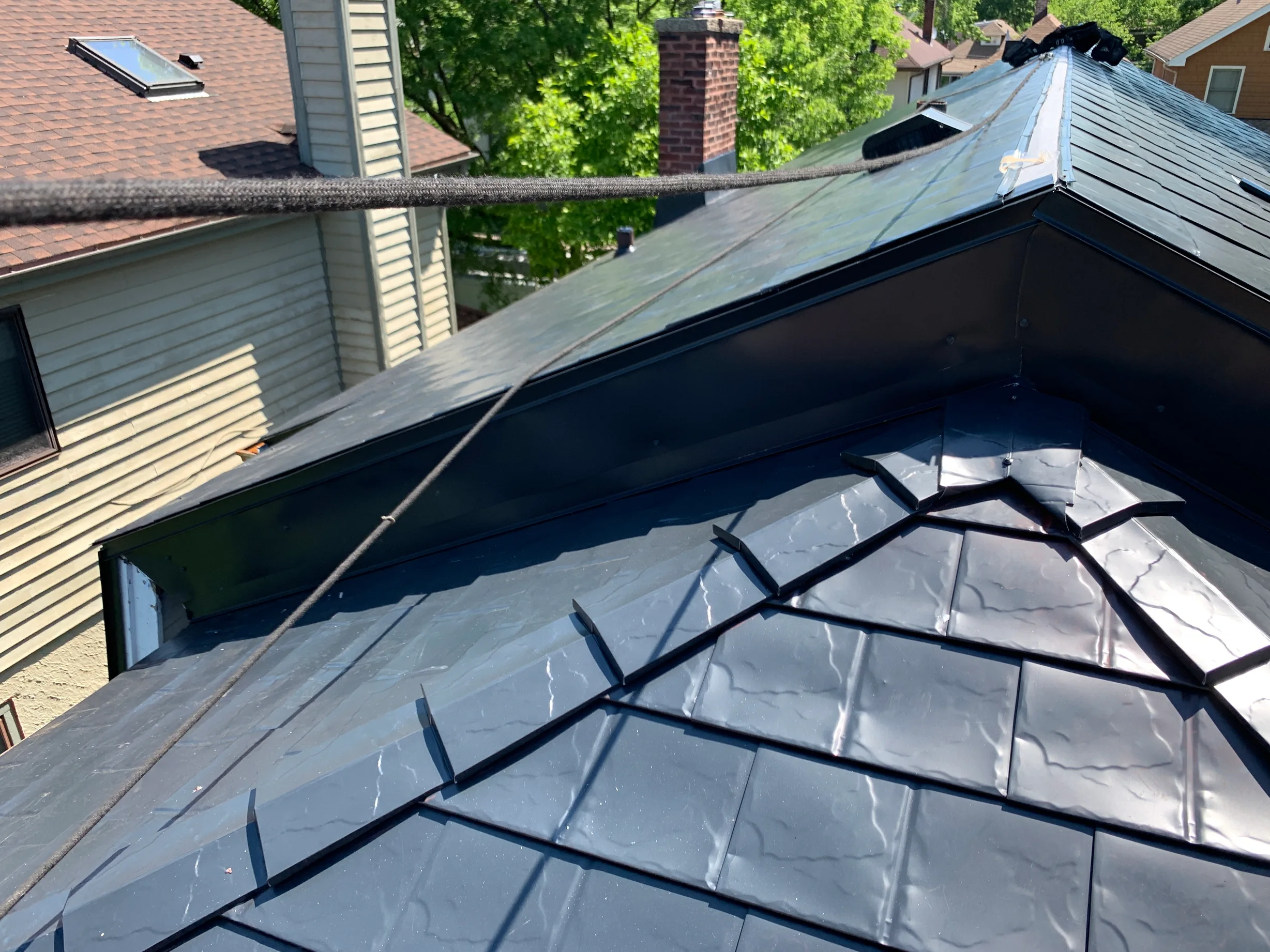 Black Interlock Slate aluminum roof on a black single-family home in a suburban area among lush, Oak Park, Illinois