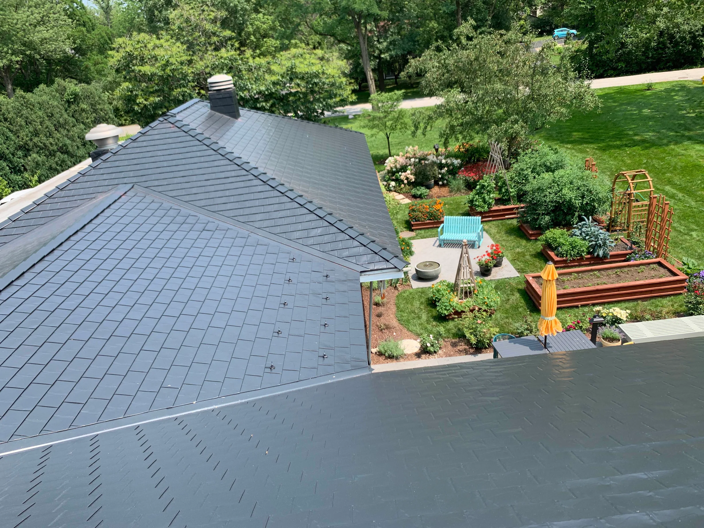 Black Interlock Slate aluminum roof on a black home with a dark roof in a forested suburban area, Flossmoor, Illinois