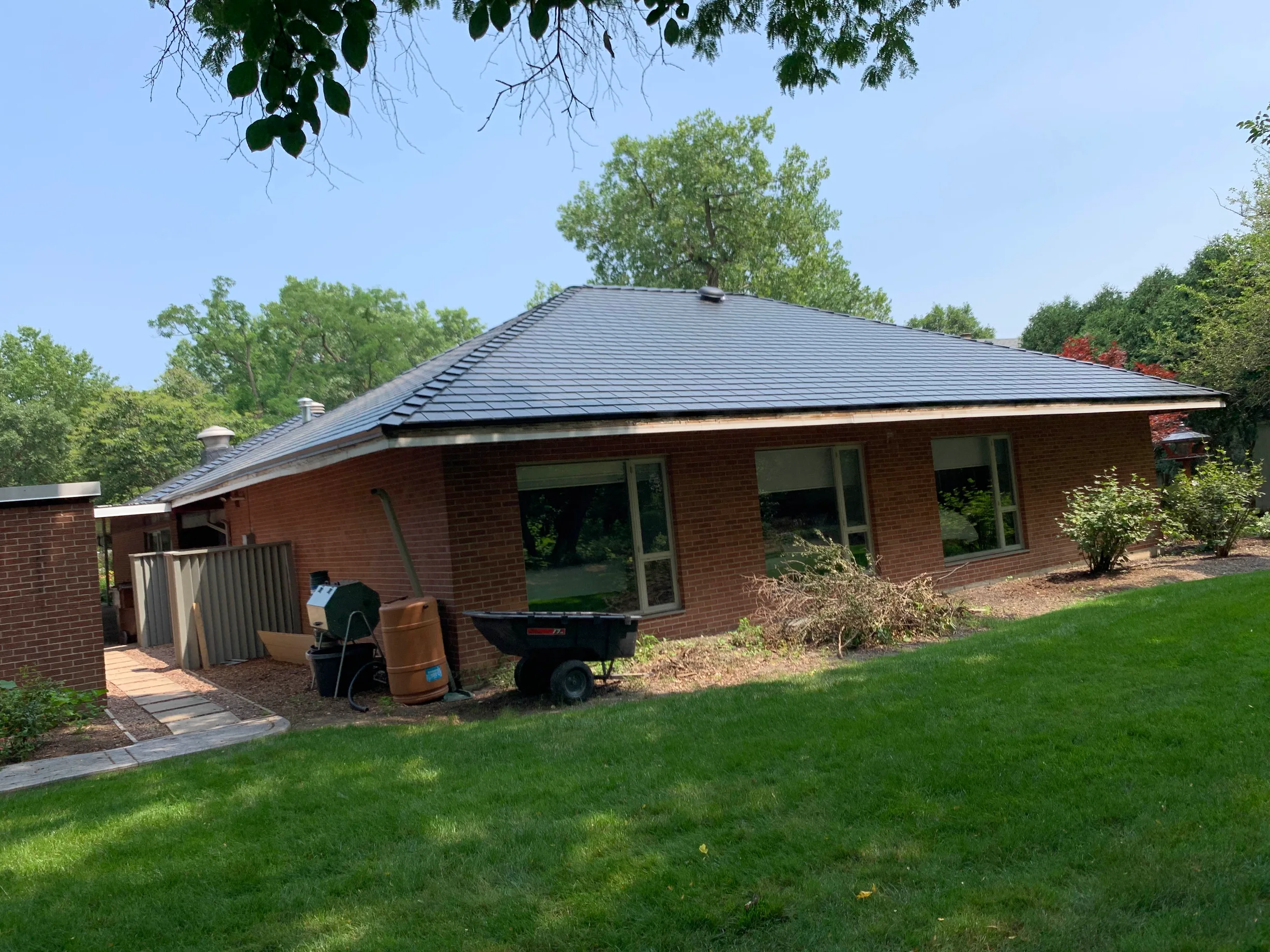 Black Interlock Slate aluminum roof on a red brick home with a grey metal roof in a suburban, Flossmoor, Illinois