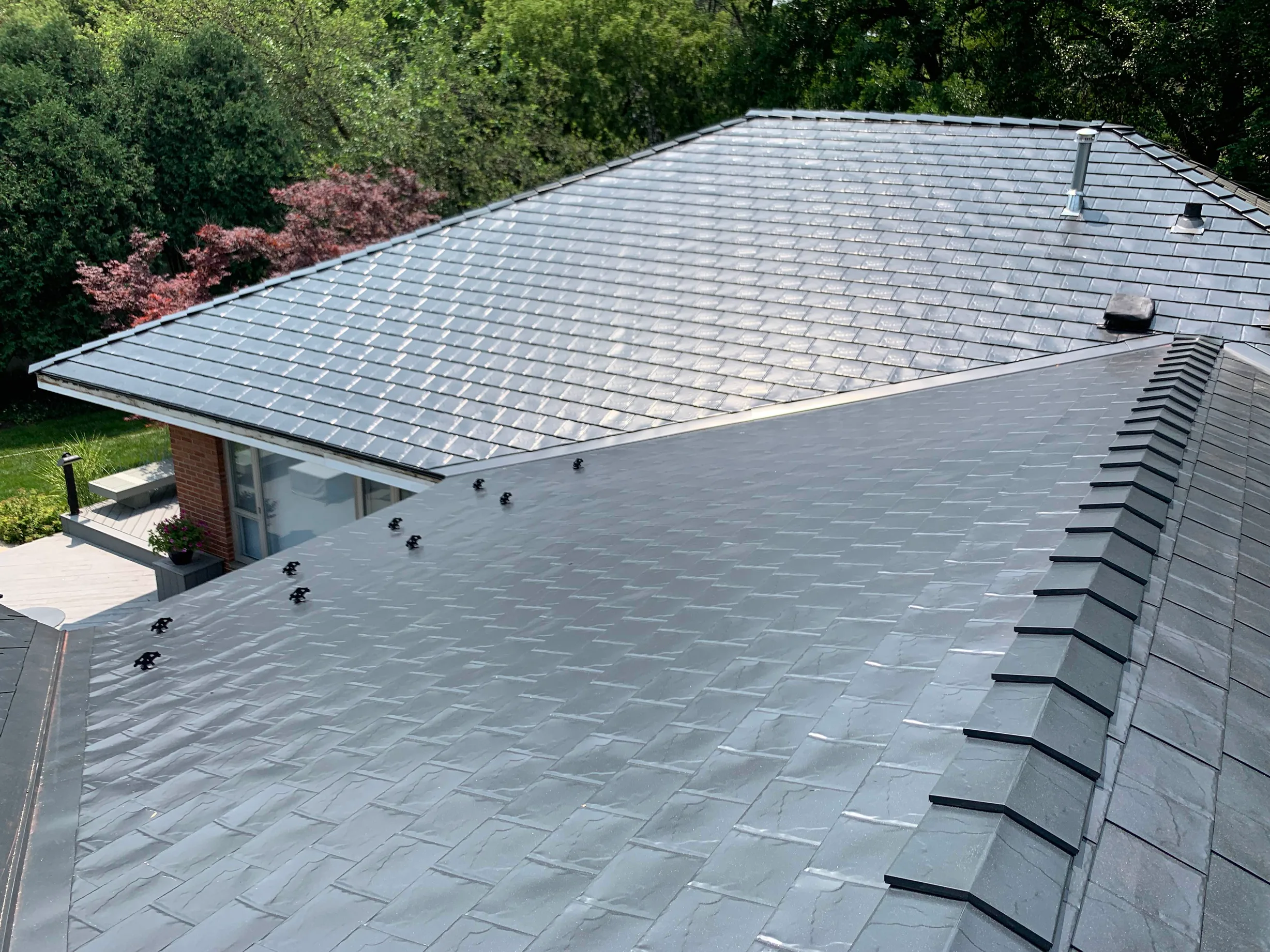 Black Interlock Slate aluminum roof on a single-family home with a metal roof in a forested setting, Flossmoor, Illinois