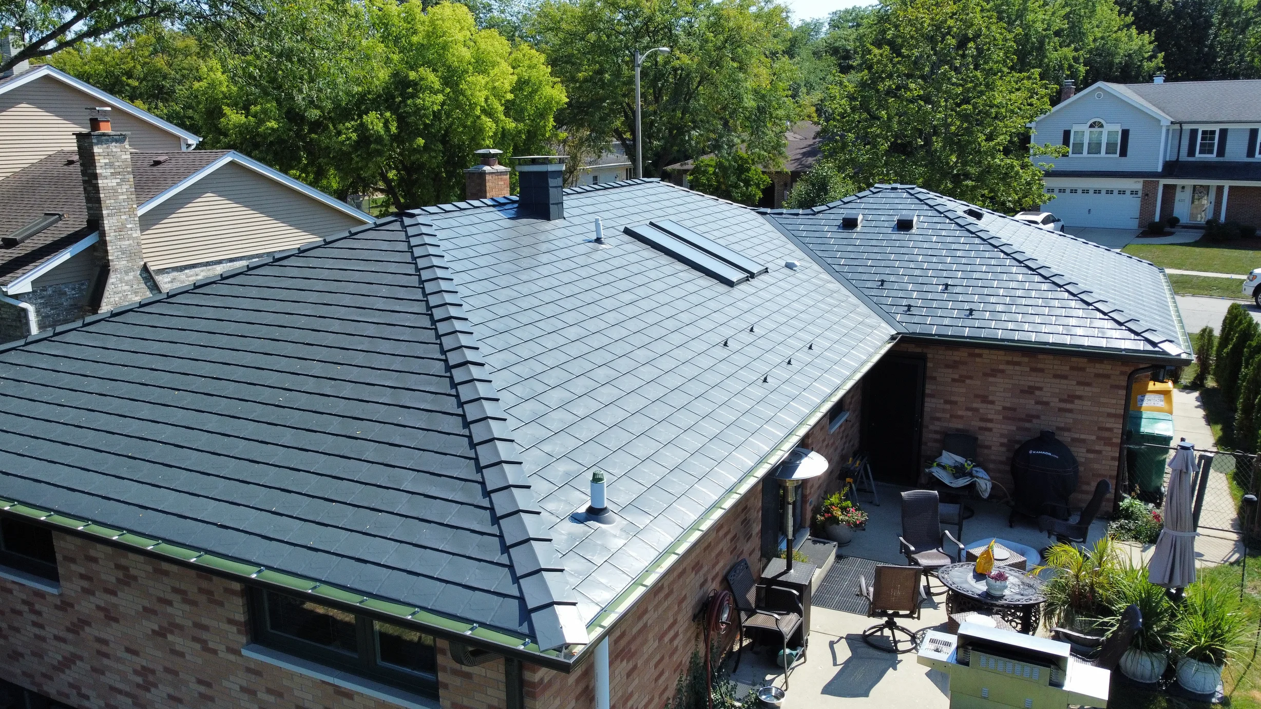 Deep Charcoal Interlock Slate aluminum roof on a two-storey single-family home with brick siding in a, Westmont, Illinois