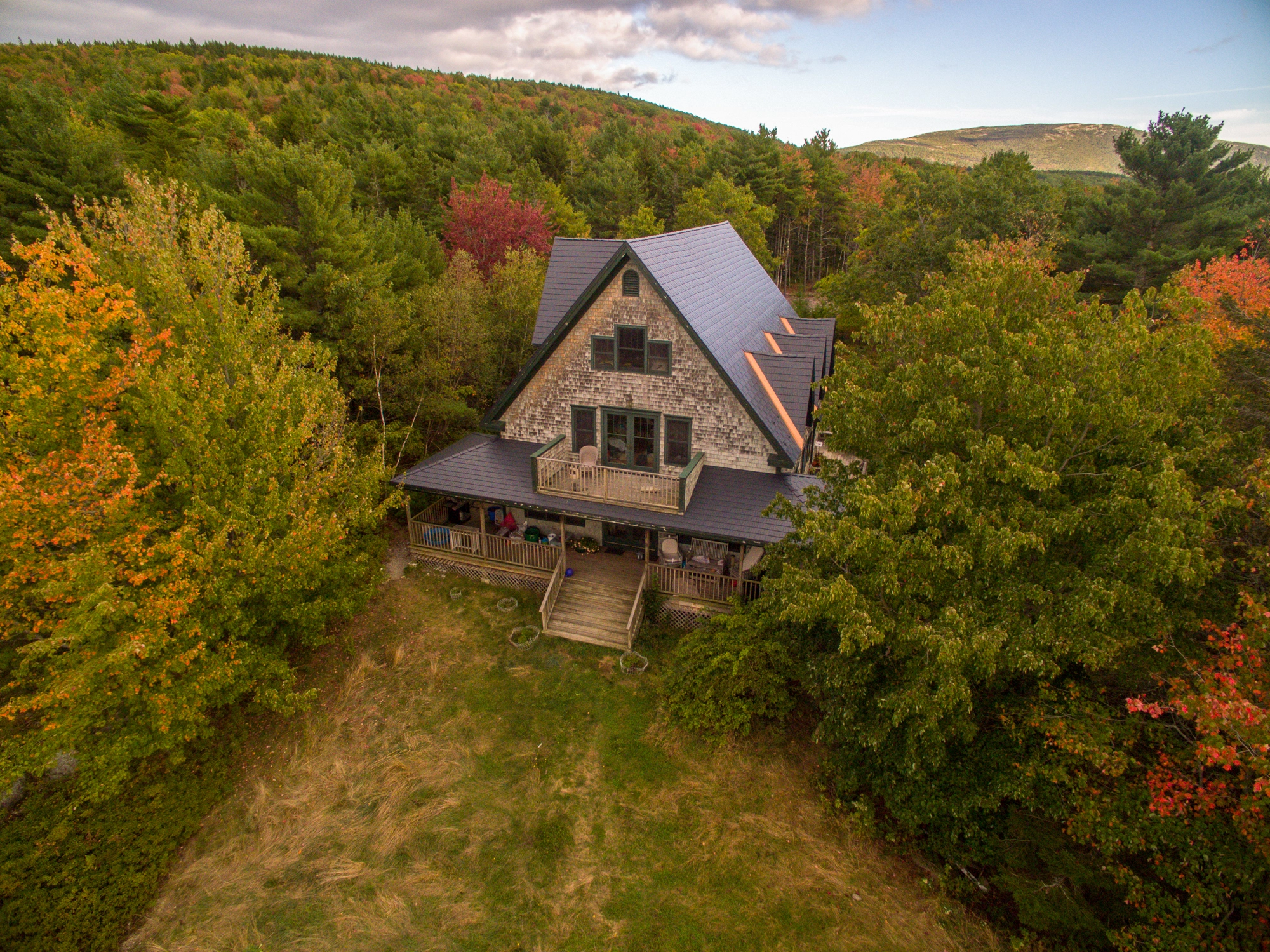 Deep Charcoal Interlock Cedar Shingle aluminum roof on a brown A-frame house in the woods, surrounded by tall trees, Bar Harbor, Maine