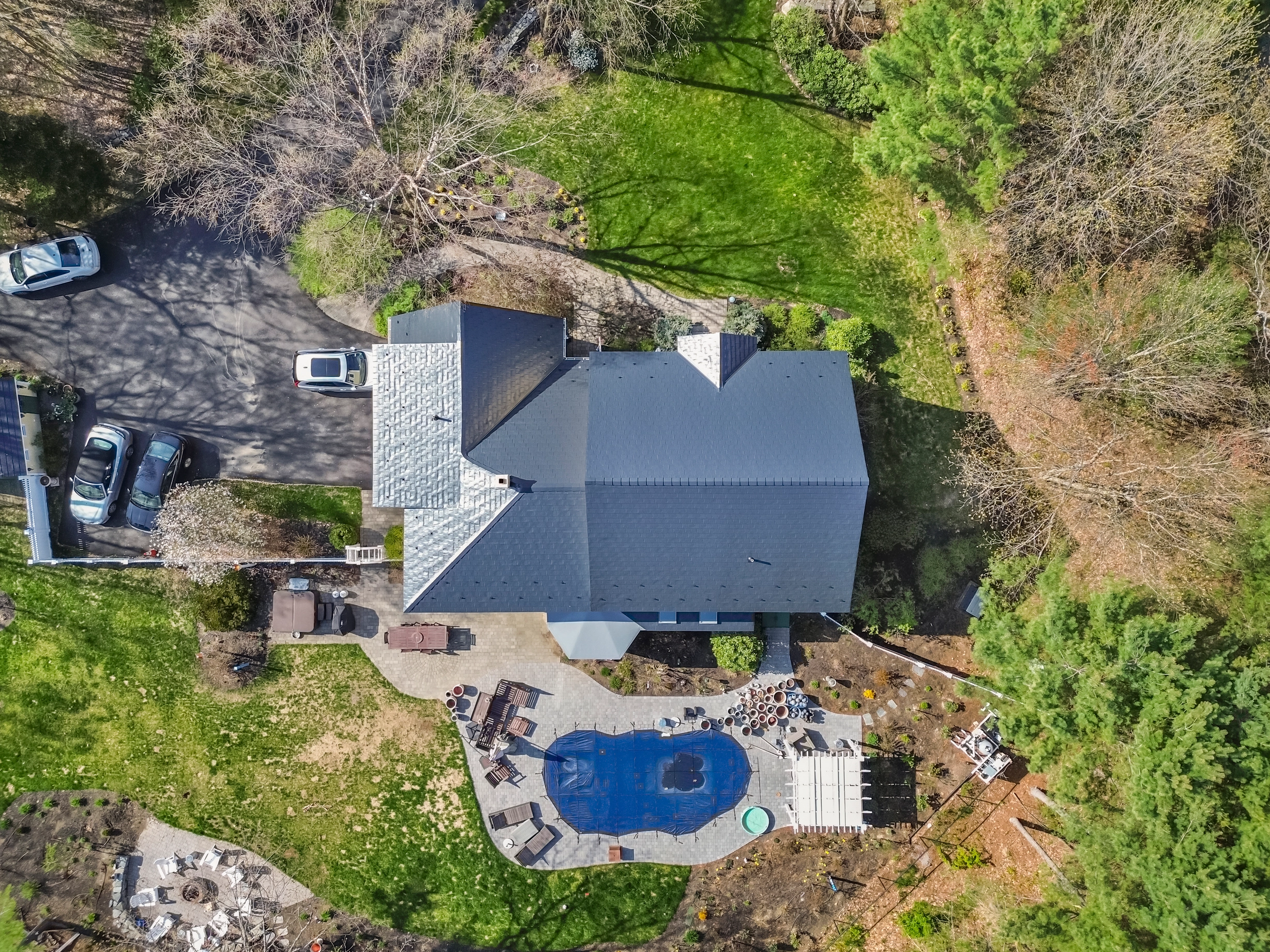 Black Interlock Slate aluminum roof on a grey colonial home with dormers in a forested setting, Brunswick, Maine