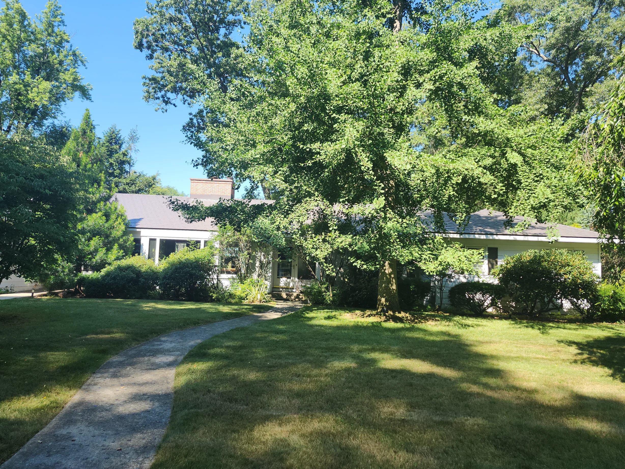 Weathered Interlock Slate aluminum roof being installed on a single-family home with a metal roof among trees, Longmeadow, Massachusetts