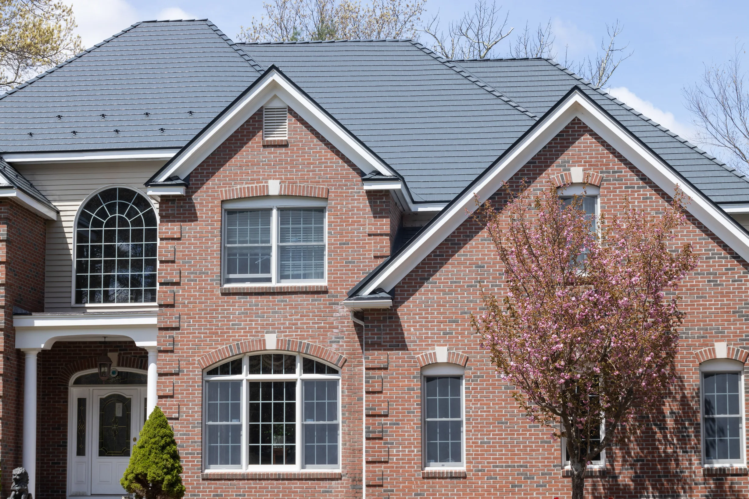 Deep Charcoal Interlock Cedar Shingle aluminum roof on a red brick colonial home with dormers in a wooded suburban, Westford, Massachusetts