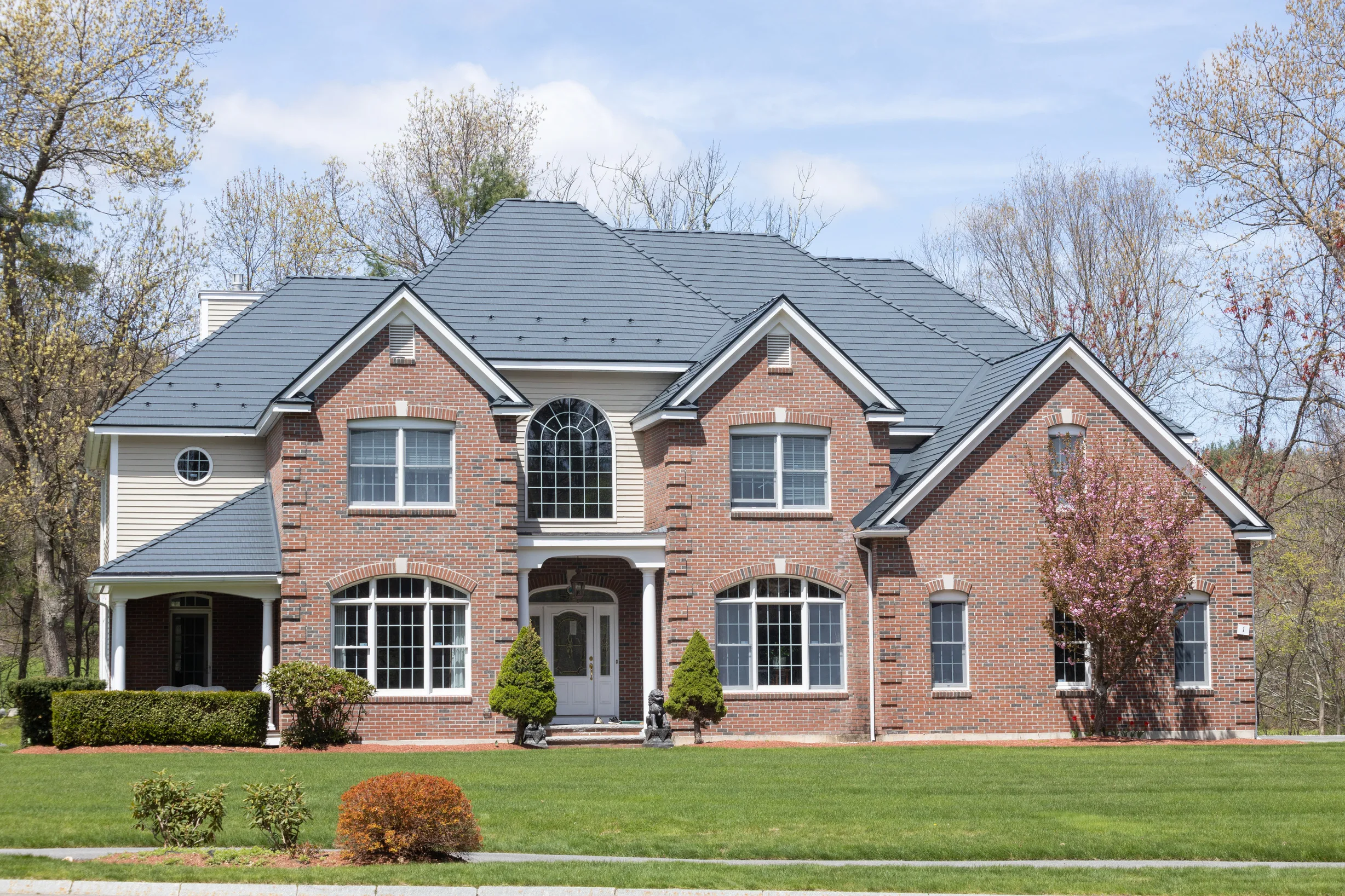 Deep Charcoal Interlock Cedar Shingle aluminum roof on a red brick two-storey colonial home with dormers among, Westford, Massachusetts