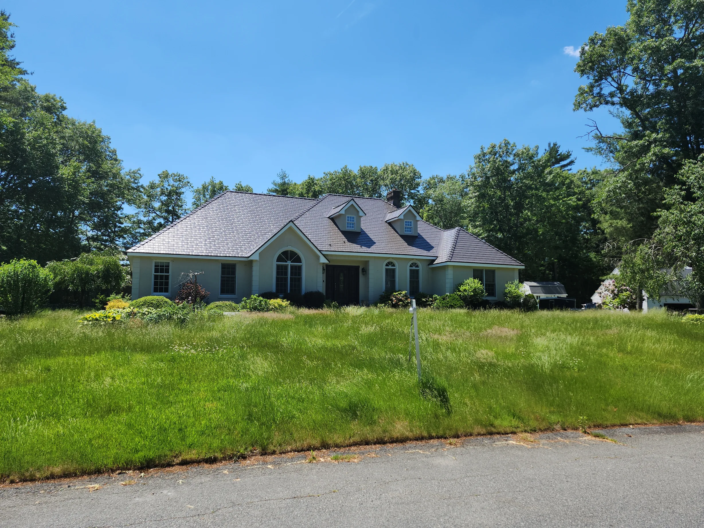 Tudor Brown Interlock Cedar Shingle aluminum roof on a Tudor Brown metal roof on a colonial home in a rural, East Taunton, Massachusetts